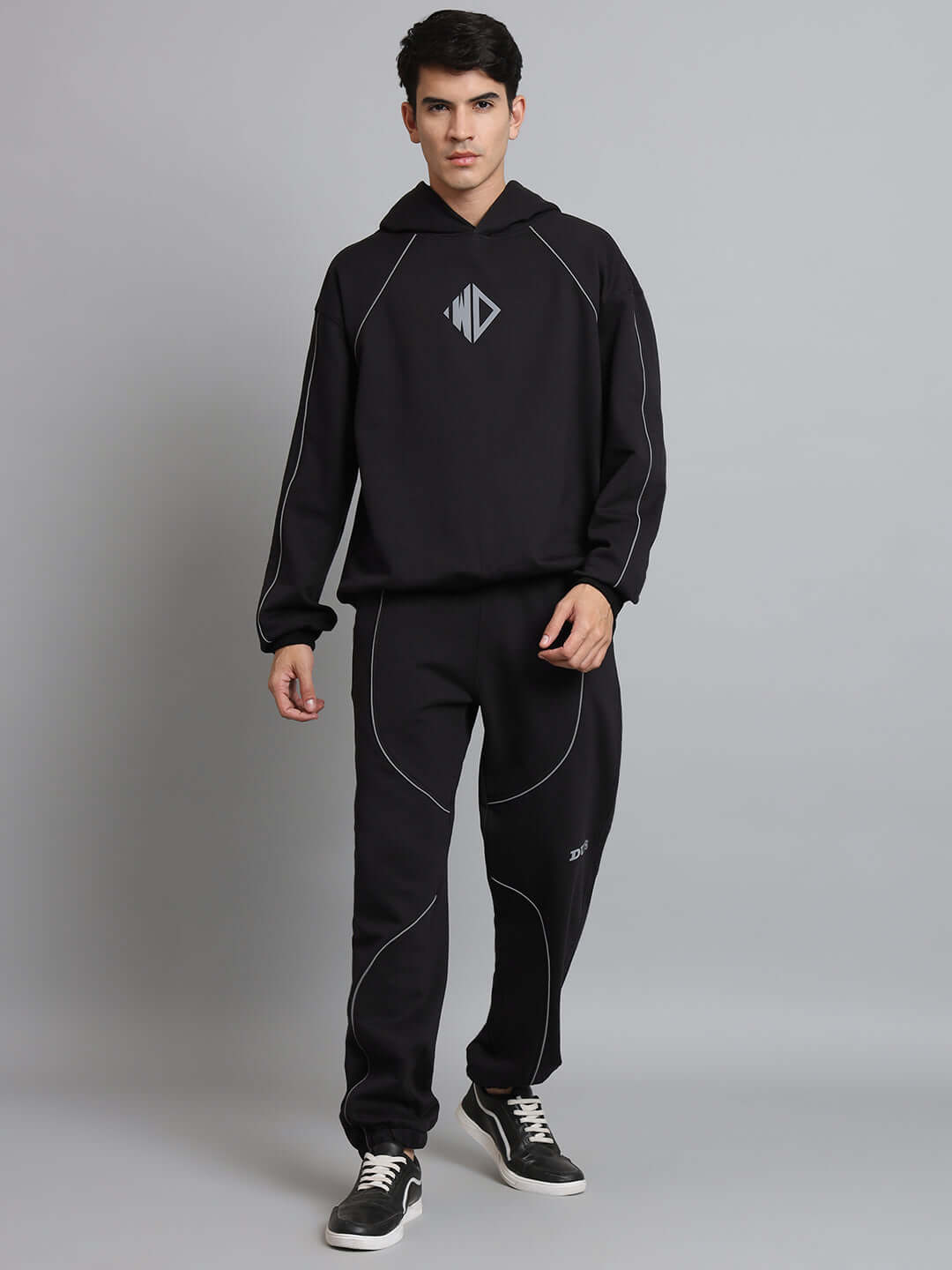 Model wearing black Armor Reflector Fleece Jogger with hooded sweatshirt, showcasing stylish and comfortable loungewear.