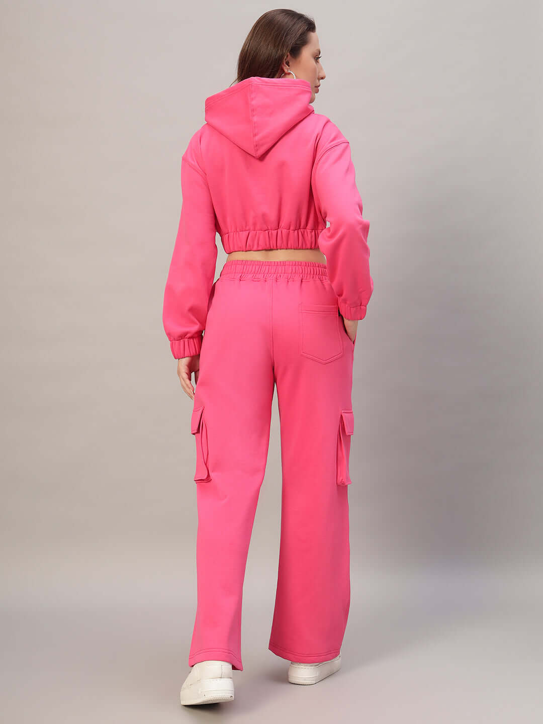 Back view of a woman wearing a pink colorblock fleece co-ord set, featuring a hooded jacket and cargo pants, highlighting comfortable style.