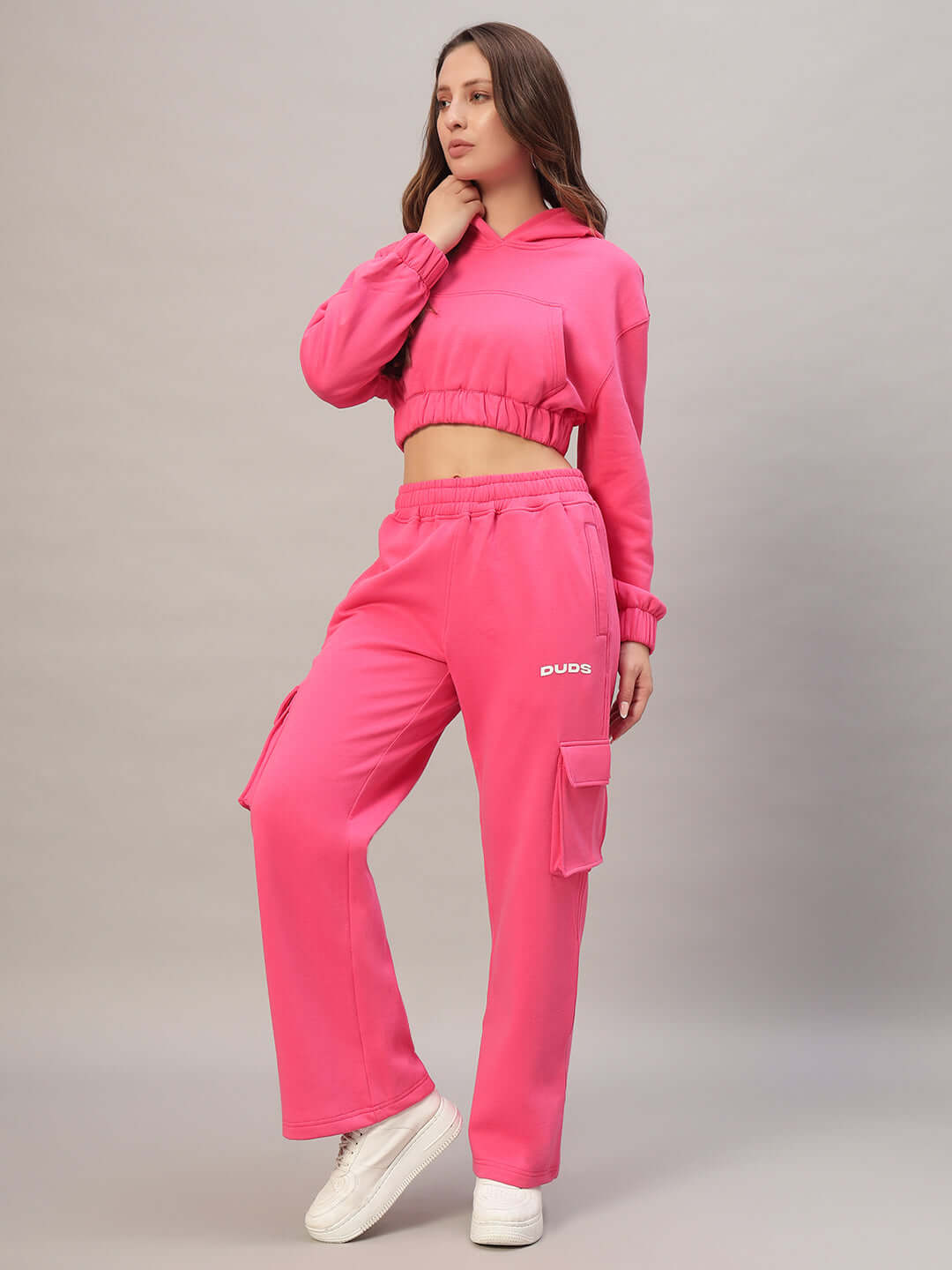Alt Tag: Woman wearing pink charm colorblock fleece co-ord set by DUDS, featuring a cropped hoodie and cargo pants.