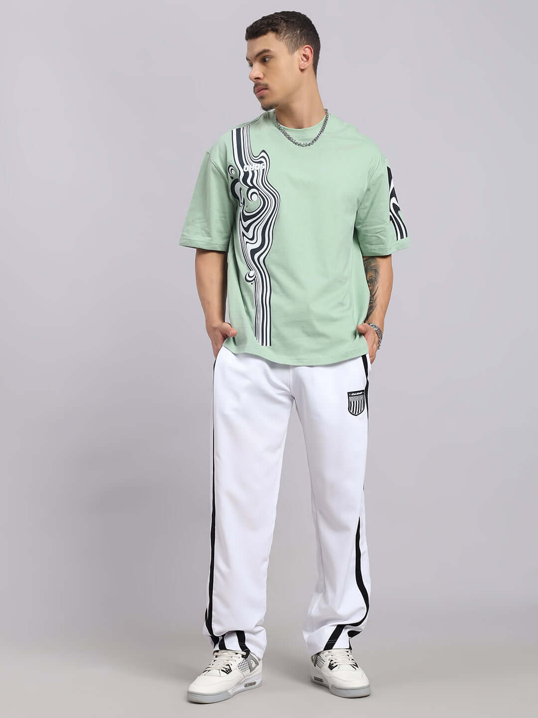 Model wearing CHIMERA Oversized T-Shirt in Nyanza Green, showcasing premium cotton French terry fabric with abstract pattern design.