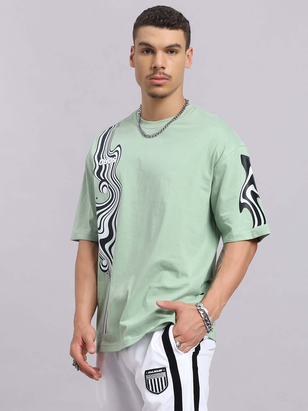 Model wearing Chimera oversized t-shirt in Nyanza Green, featuring a stylish abstract design, made of premium cotton blend.