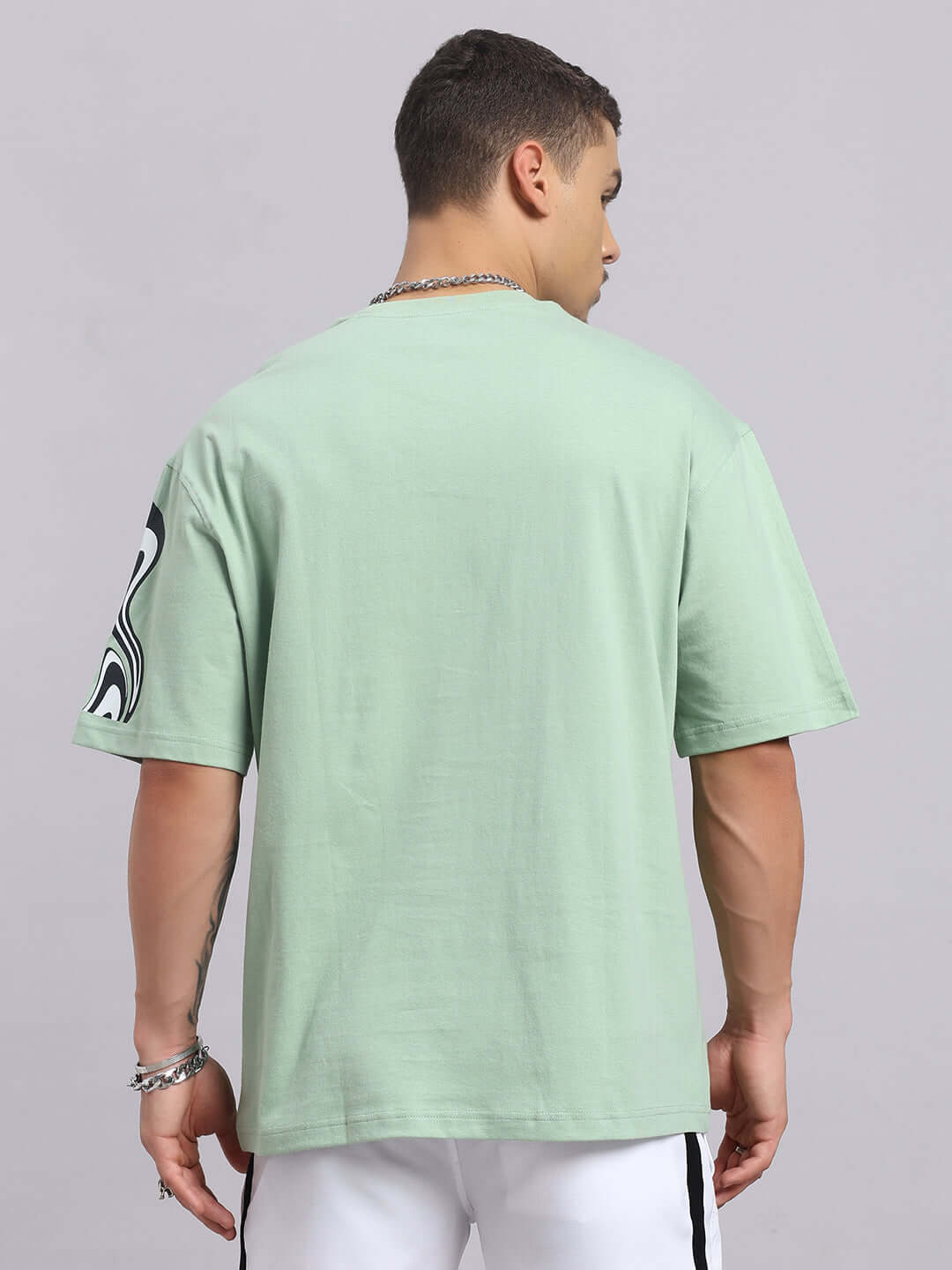 Back view of Chimera oversized t-shirt in Nyanza green, made from premium cotton French terry with graphic sleeve detail.