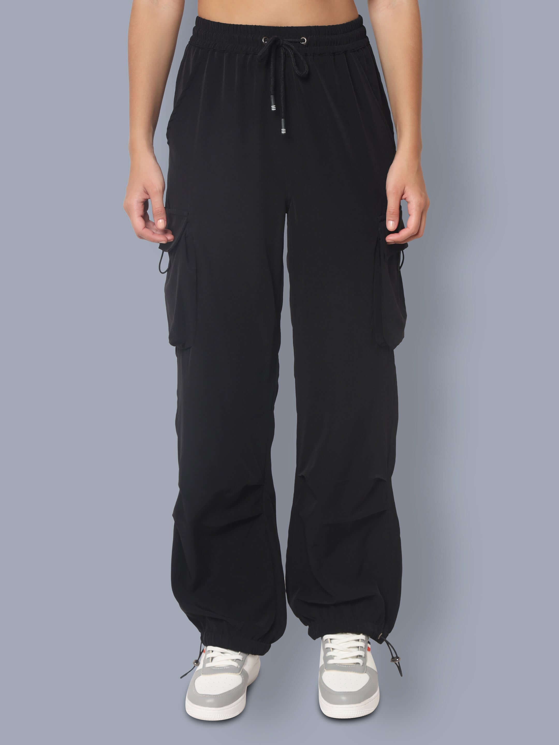 Black women's tactical cargo joggers with drawstring waist and side pockets, shown on a person standing.