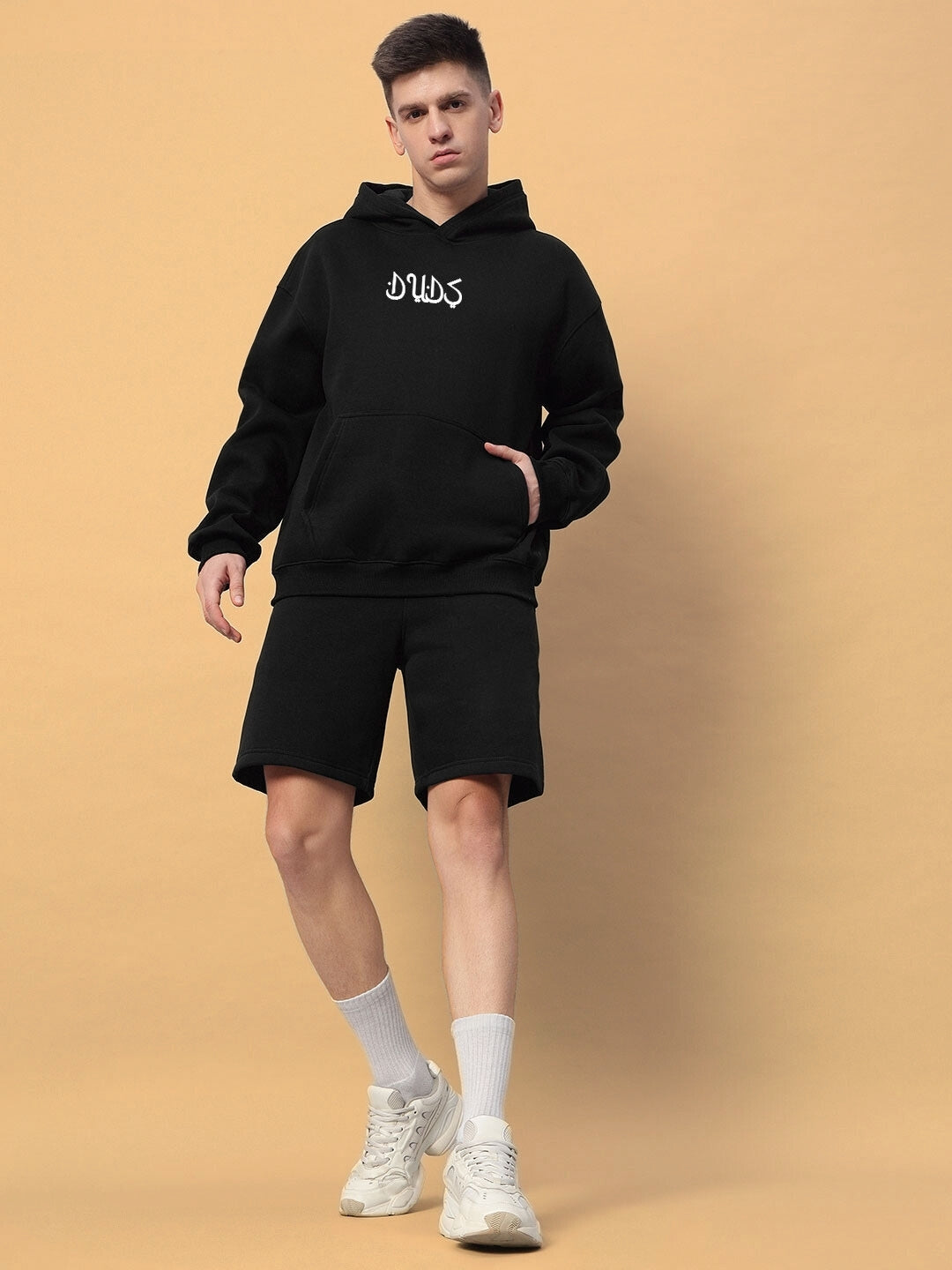 Model wearing Dimension Cotton Fleece Co-Ord in black, featuring a hoodie and shorts, stylish and comfortable for casual wear.