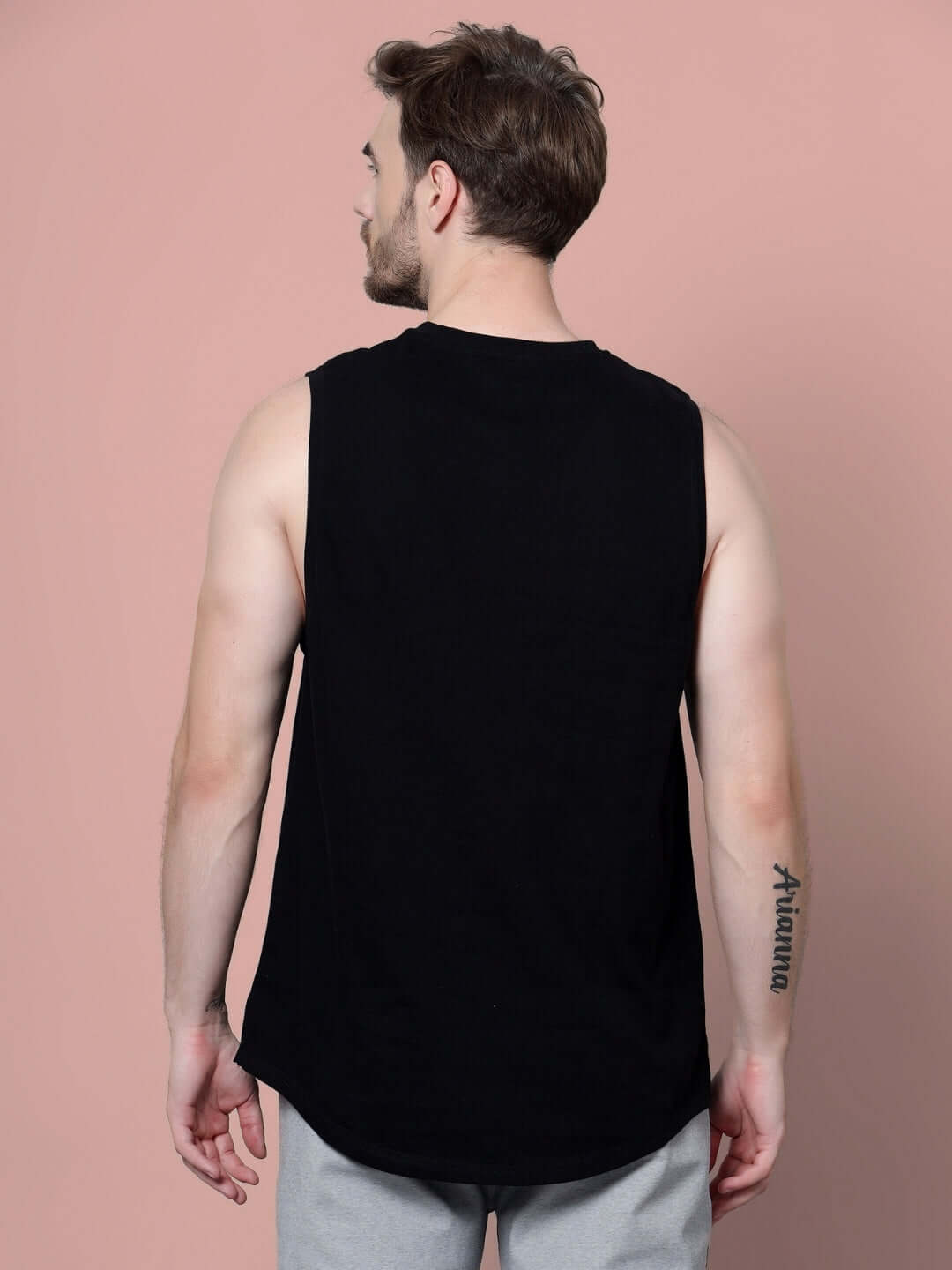 Back view of model wearing GOODY GYM COTTON T-SHIRT BLACK showcasing the sleeveless design and athletic fit for workouts.