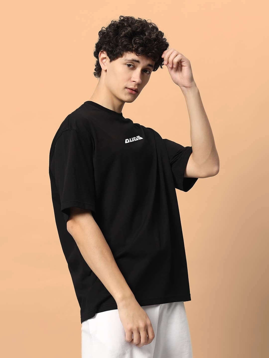 TOO LOUD OVER-SIZED T-SHIRT BLACK featuring a model in a casual pose with beige background, perfect for those seeking comfortable style.