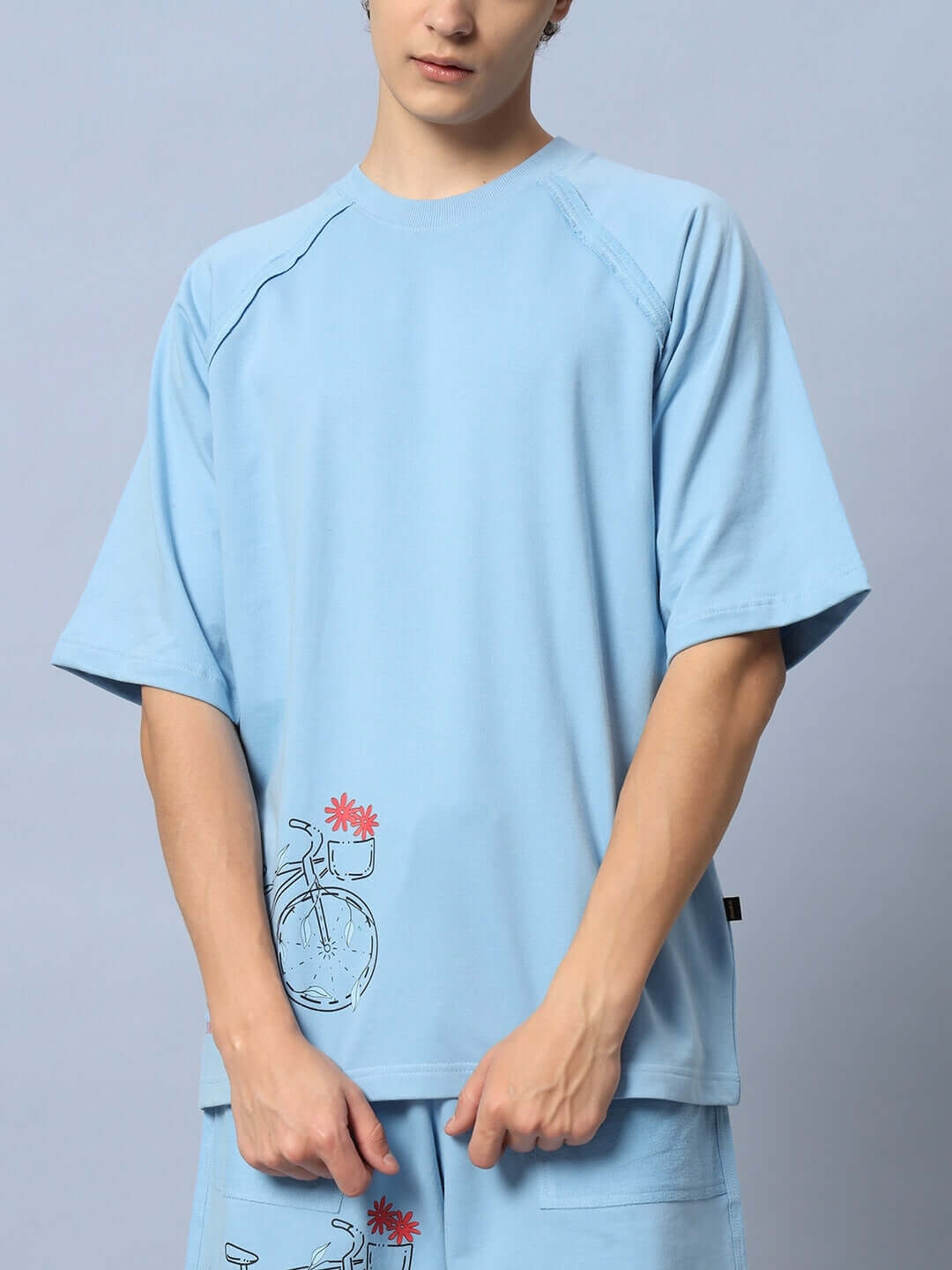 Person wearing ENJOY THE RIDE PRINTED CO-ORD SET BLUE with bicycle design on top.