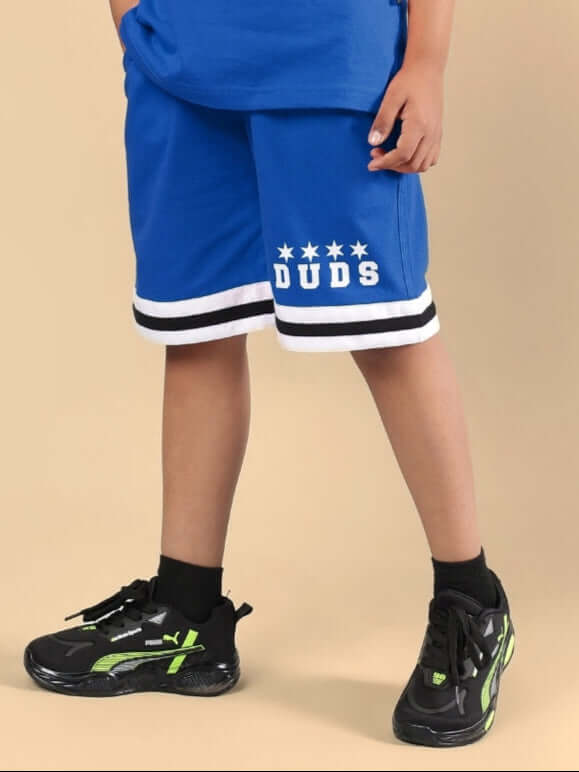 Alt Tag: Blue DIGGIN shorts for boys and girls by DUDS, featuring black sneakers. Made to order with customization option available.