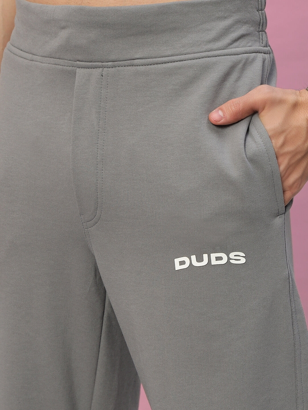 Grey New Era Relaxed Fit Joggers by DUDS with hand in pocket, showcasing comfort and style.