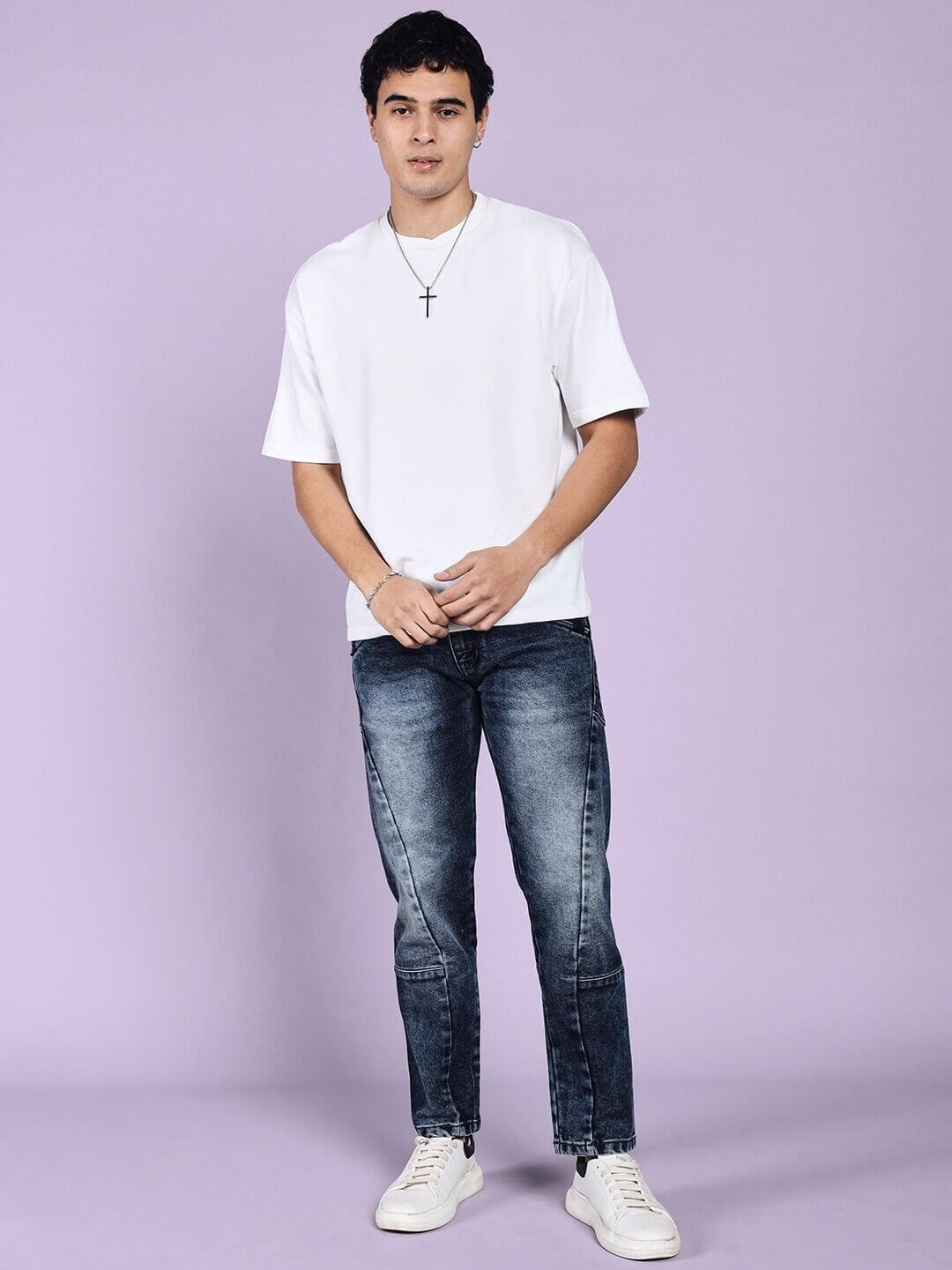 Model wearing LAPIS faded regular fit denim jeans in blue with a white shirt in front of a lavender background.