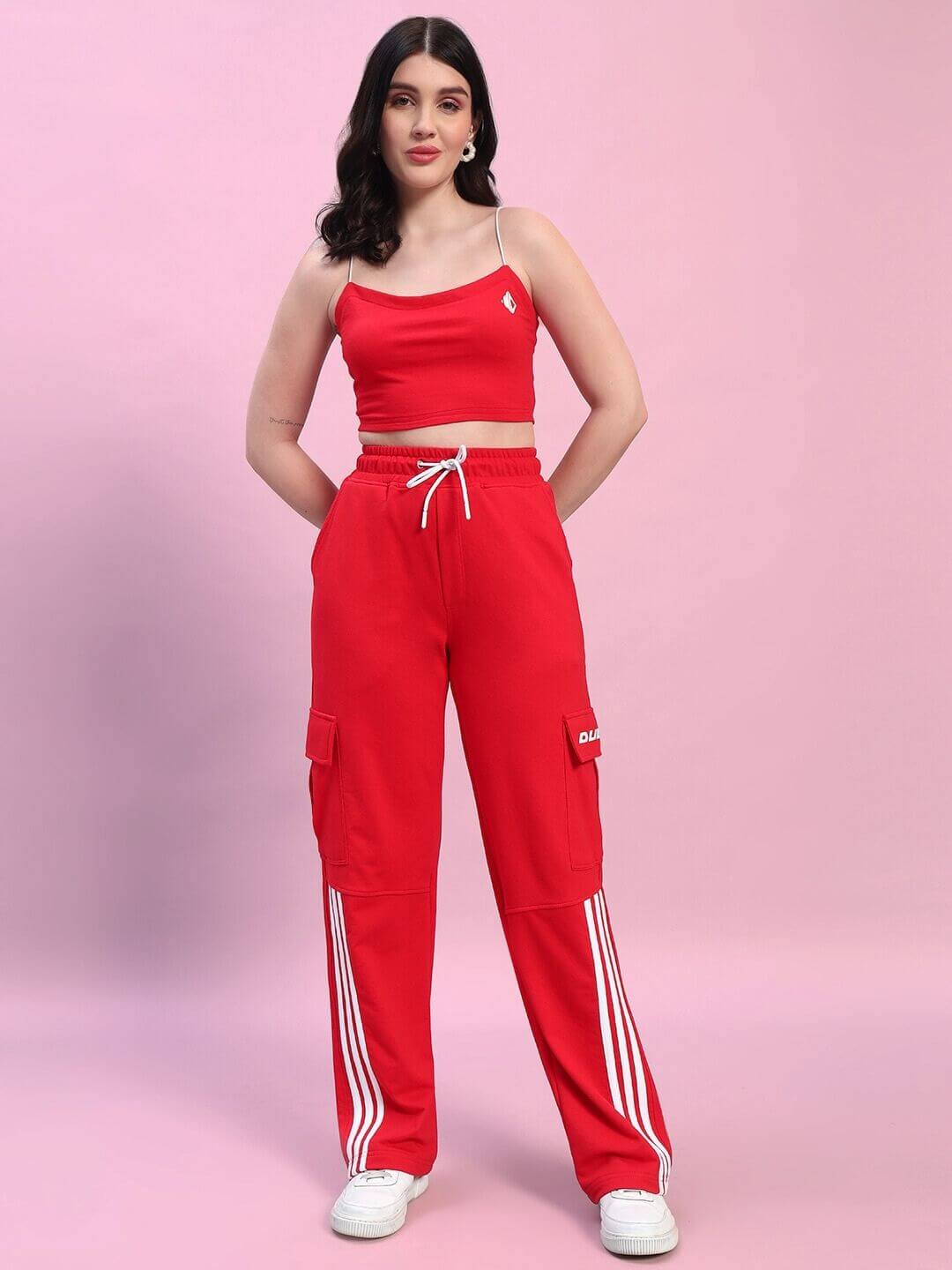 Model wearing Women's Rosella Co-ord Set in red, featuring a sleeveless top and matching pants with white stripes, showcasing fashion style.
