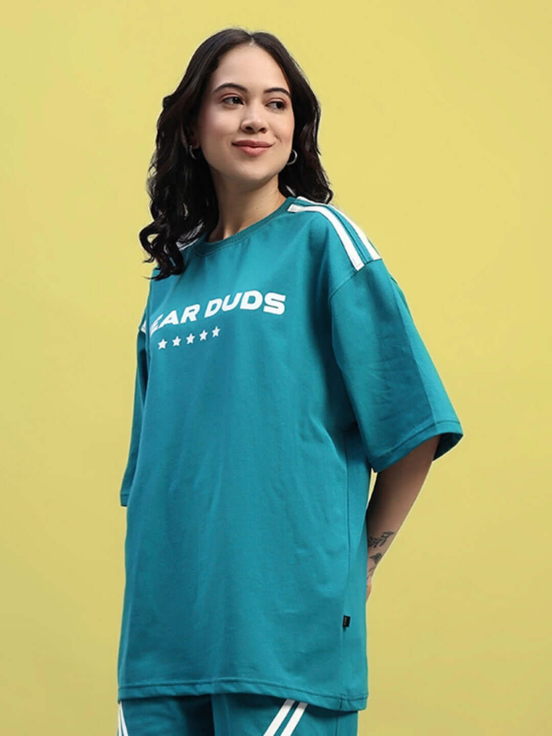 Woman wearing teal oversized star jumper t-shirt made from premium cotton, featuring a relaxed fit for casual style.