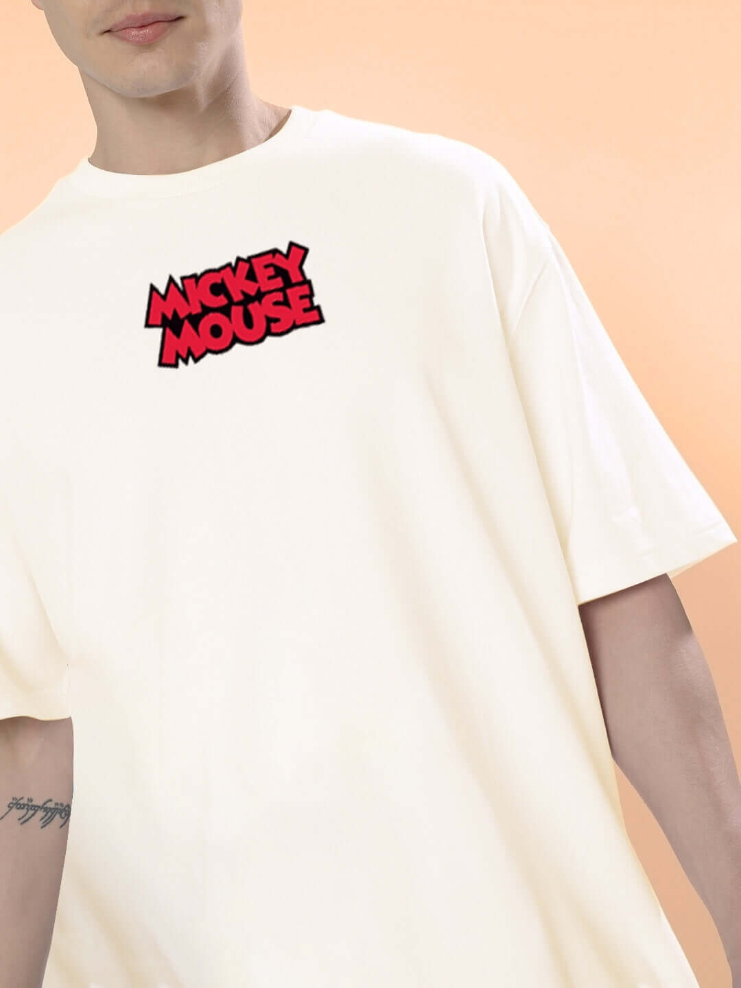 Person wearing DUDS MOUSE OVER-SIZED T-SHIRT OFF WHITE with Mickey Mouse logo on the front, ideal for a casual look.