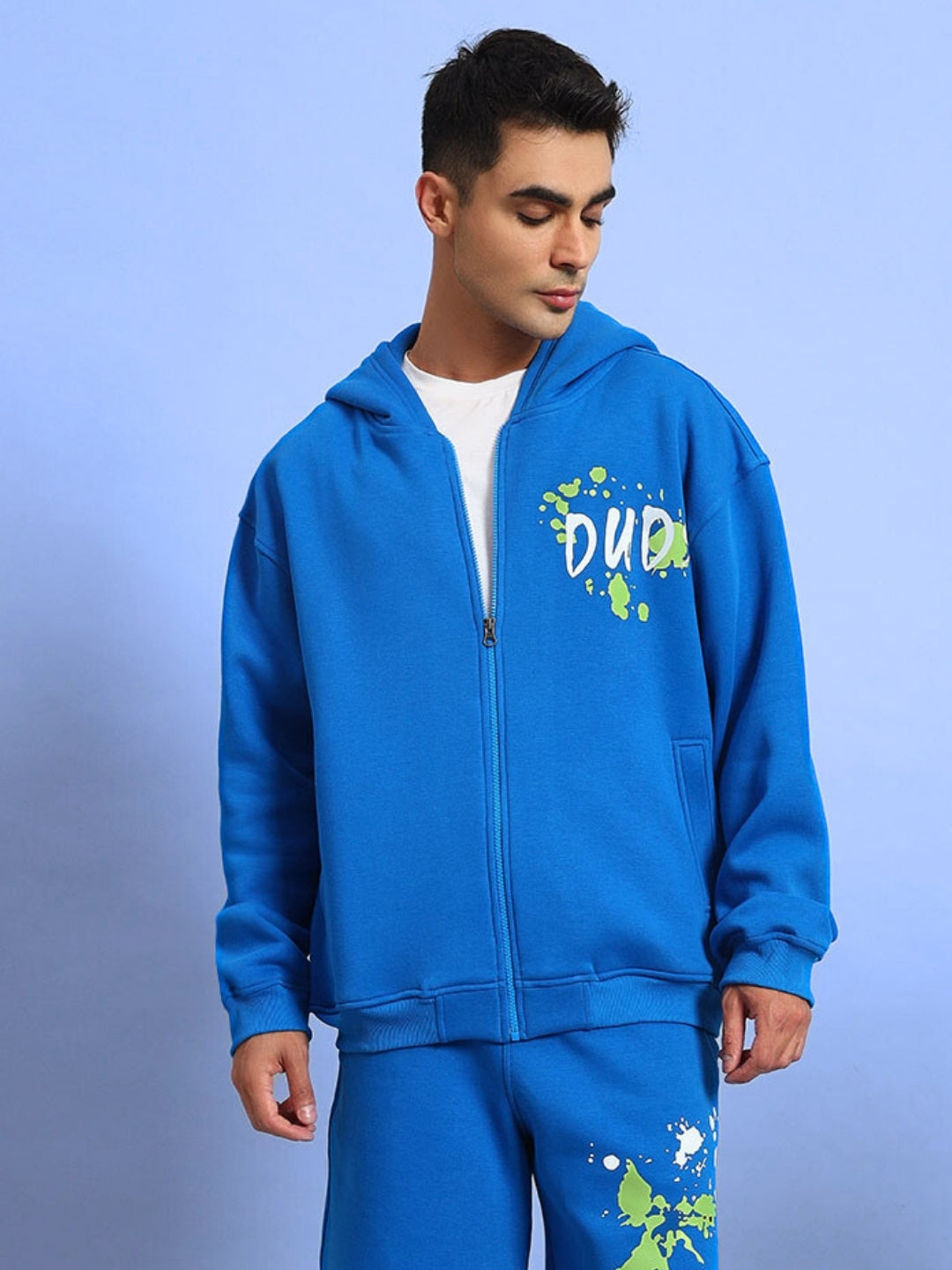 Person wearing NO DRAMA FLEECE CO-ORD in royal blue with graphic print, showcasing a stylish casual outfit against a light blue background.
