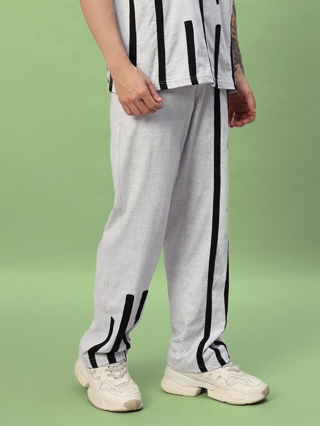 Model wearing Bastille Jogger in melange grey by DUDS, featuring black vertical stripes, made-to-order with custom fit options.