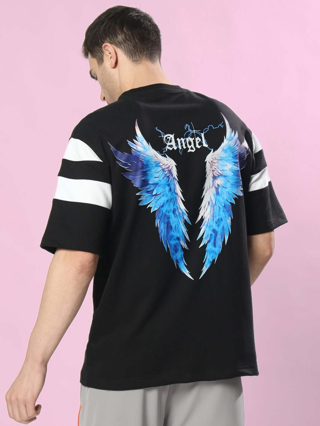 Man wearing DIVINE SPIRIT OVERSIZED T-SHIRT BLACK with angel wing design on the back