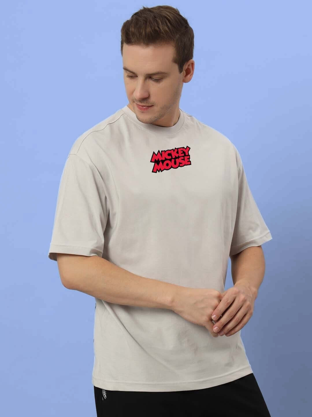 Man wearing DUDS MOUSE OVER-SIZED T-SHIRT GREY with Mickey Mouse logo, available with custom fit options for personalized sizing.