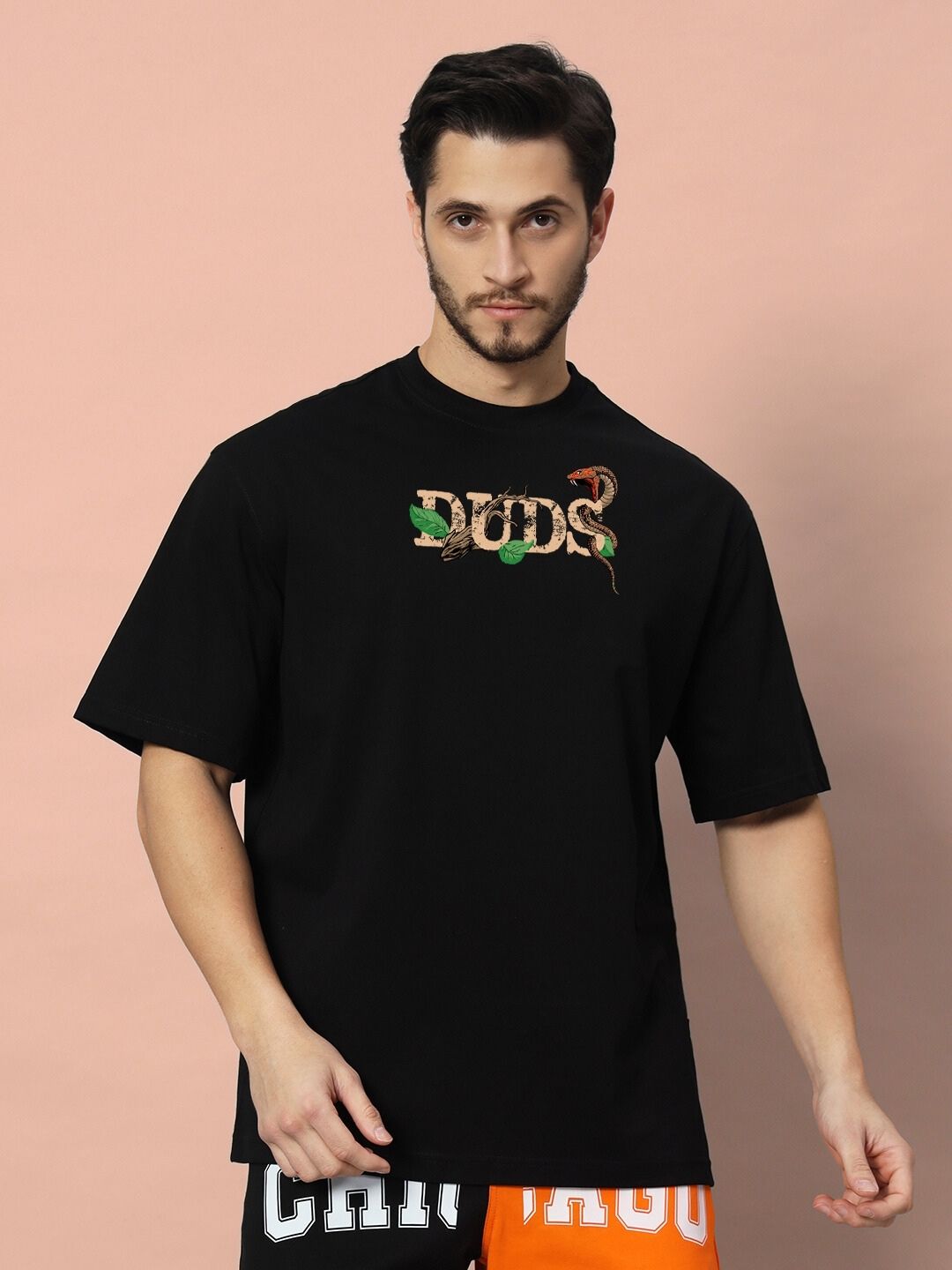 Model wearing HAND SNAKE APPLE OVERSIZED T-SHIRT BLACK with front design, standing against a neutral background.