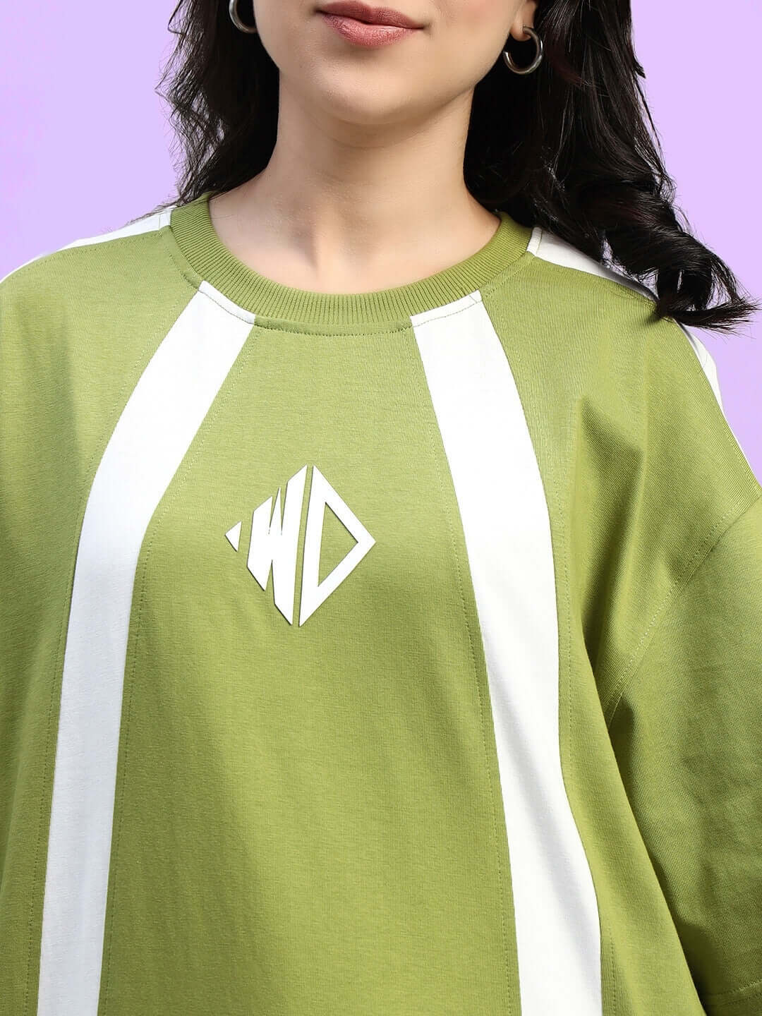 Woman wearing olive green oversized t-shirt with white stripes and logo on front; made of premium cotton fabric.