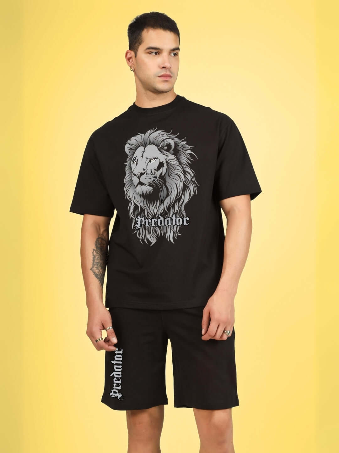 Man wearing Predator Legend Black Co-Ord Set with lion print, featuring premium cotton terry fabric, on a yellow background.