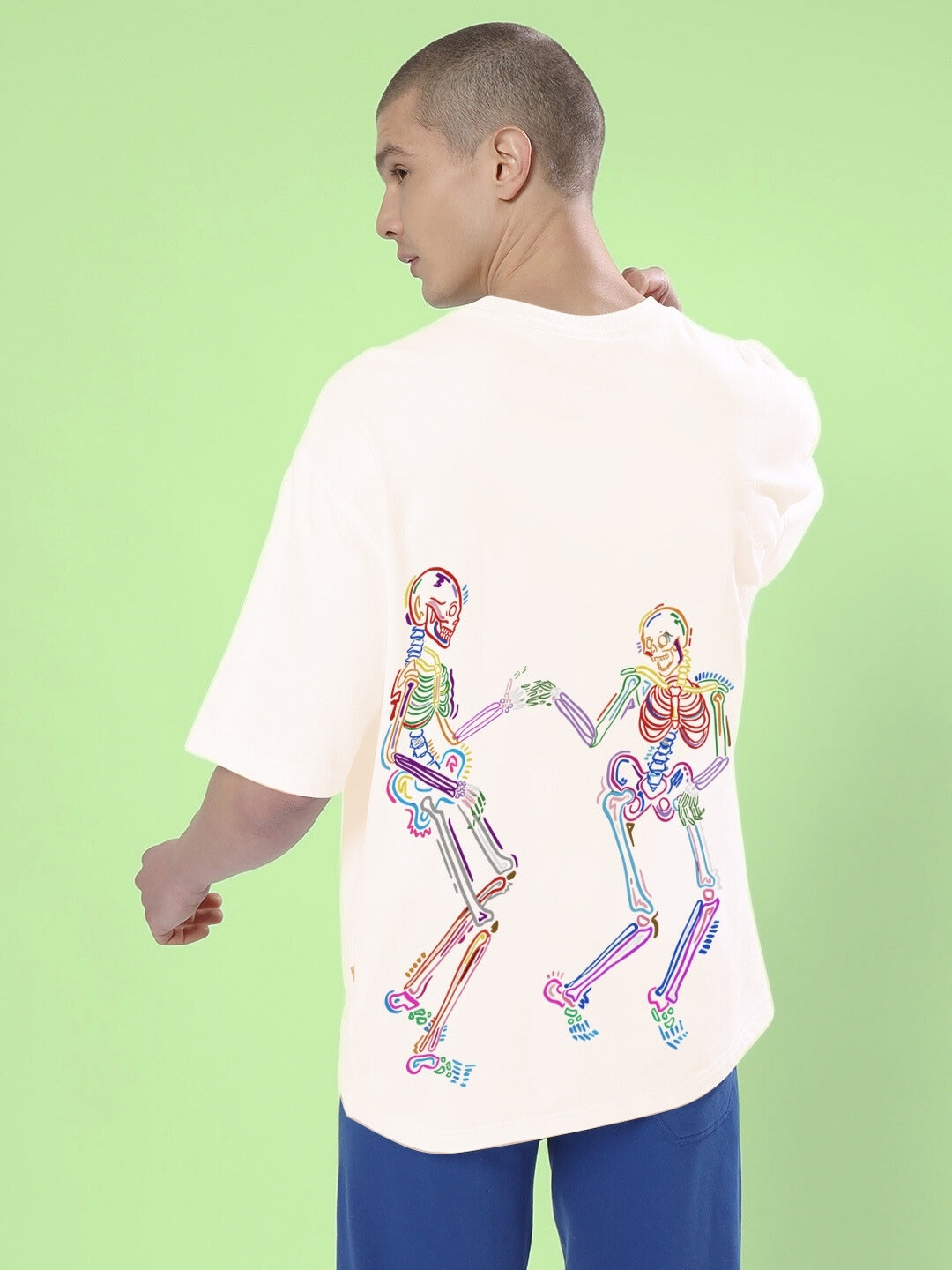 Model wearing SKULL ROLL OVERSIZED T-SHIRT OFF WHITE with colorful skeleton design on the back