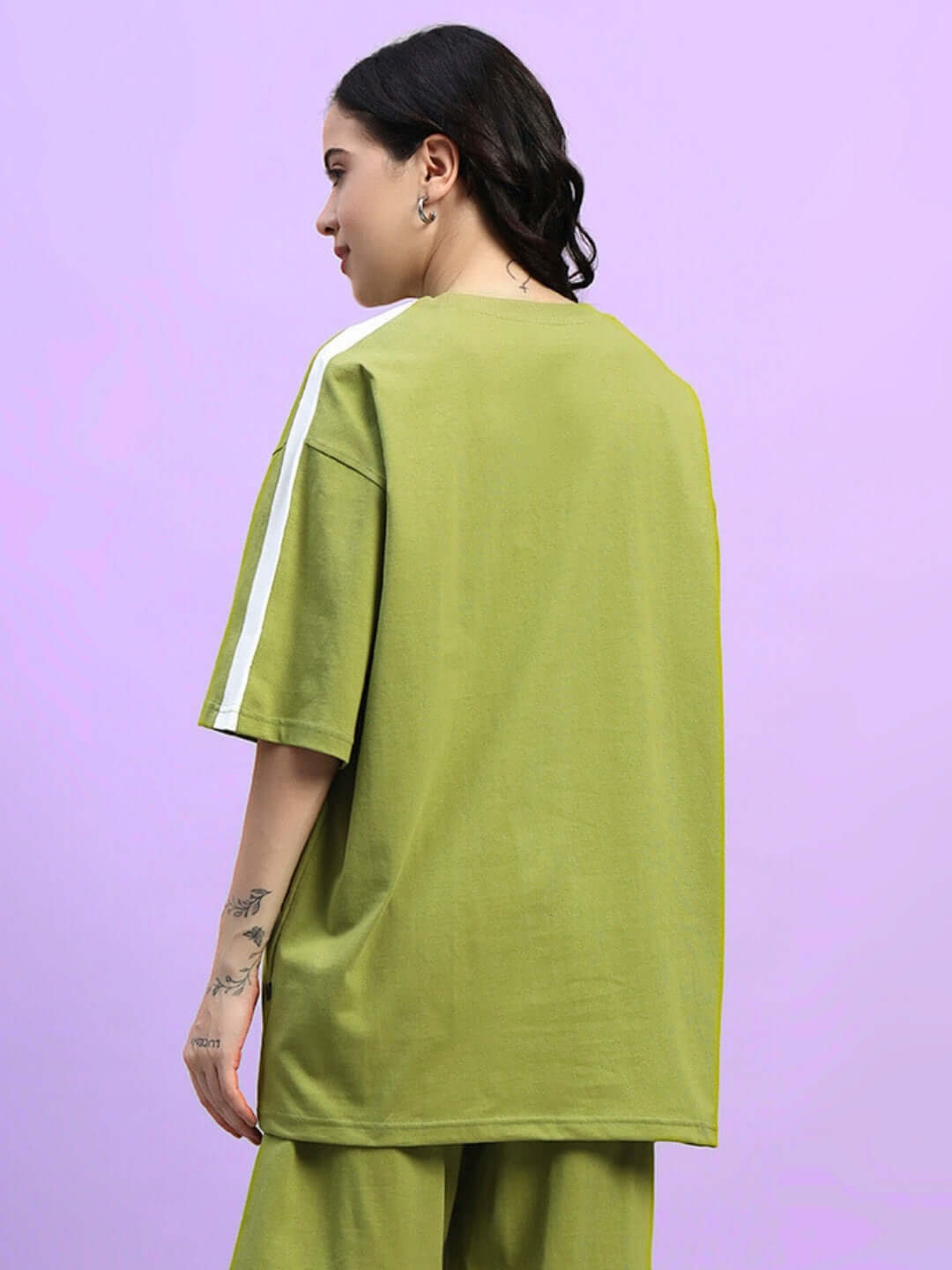 Woman wearing oversized olive green t-shirt made from premium cotton and elastane, rear view, perfect for casual wear. Made in India.