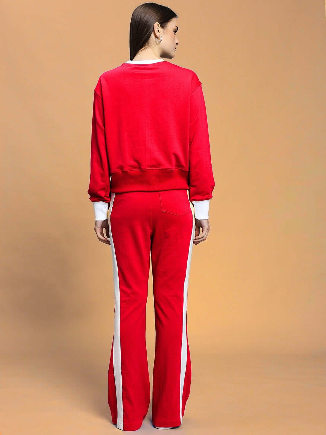 Back view of a woman wearing a red relaxed fit co-ord set with white side panels, featuring an elasticated waistband and drawstring.