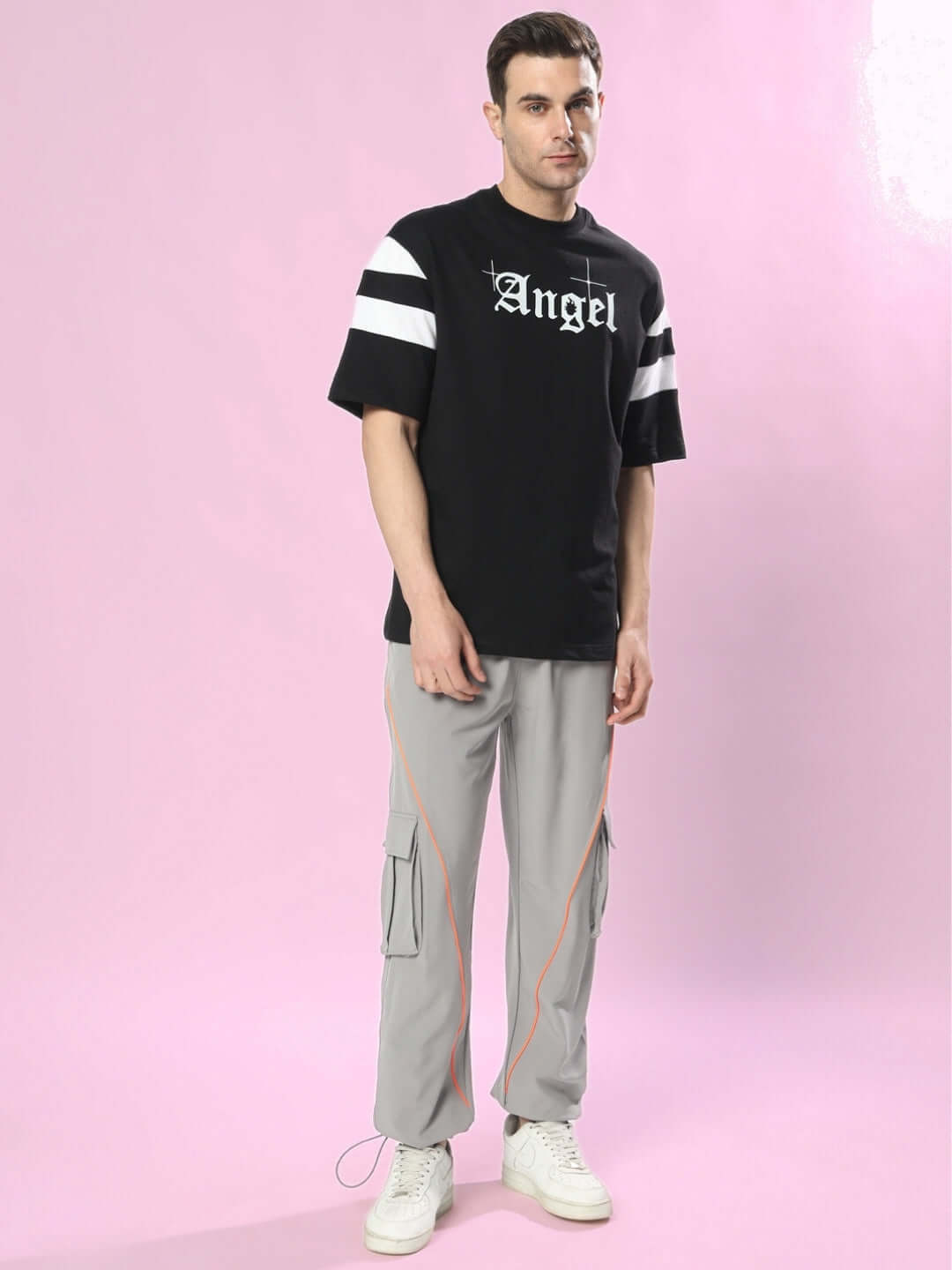 Model wearing DIVINE SPIRIT OVERSIZED T-SHIRT BLACK with premium heavy gauge fabric and cotton blend, styled against a pink background.
