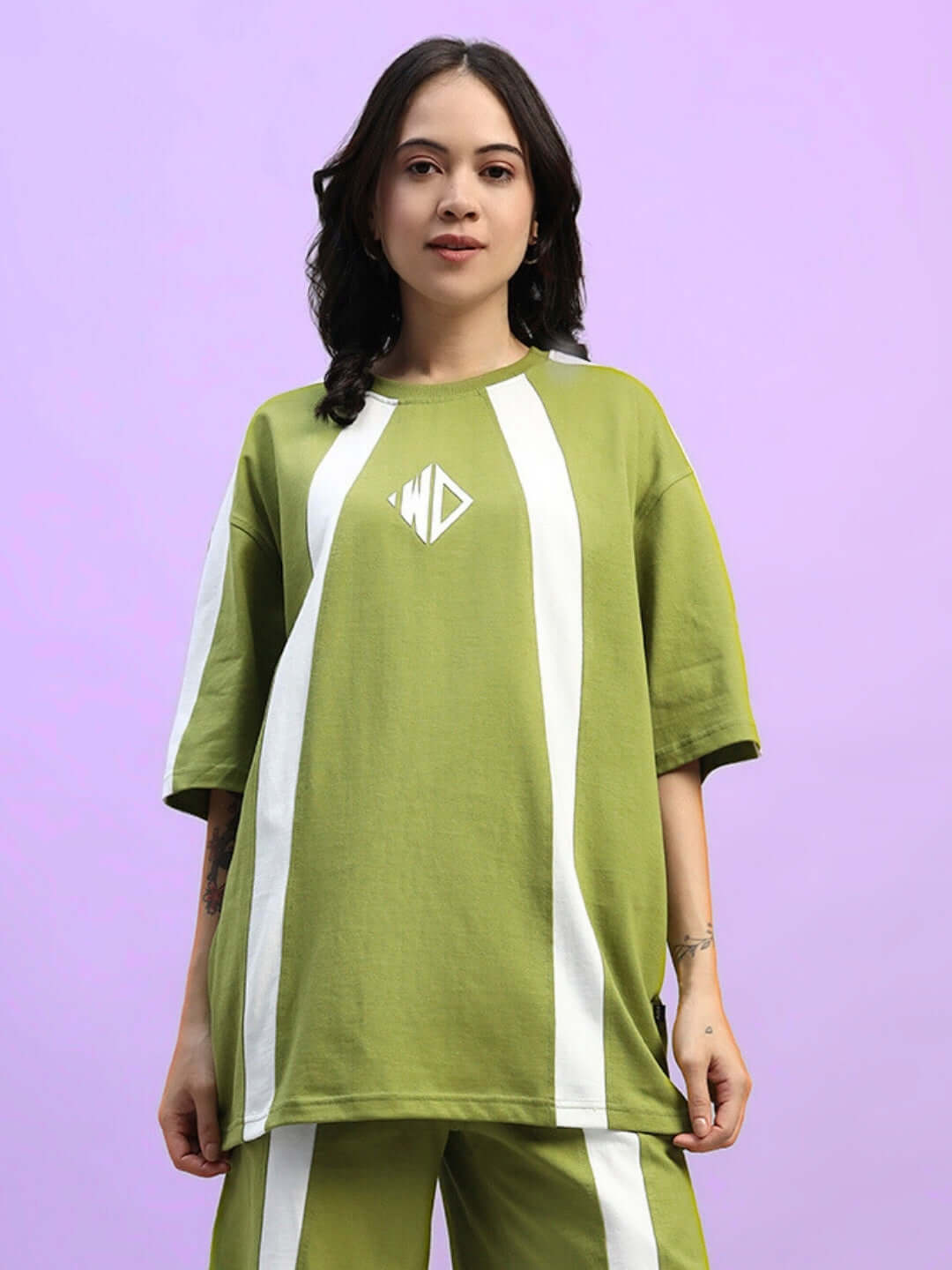 Woman wearing olive green oversized t-shirt with white stripes, premium cotton fabric, casual wear.