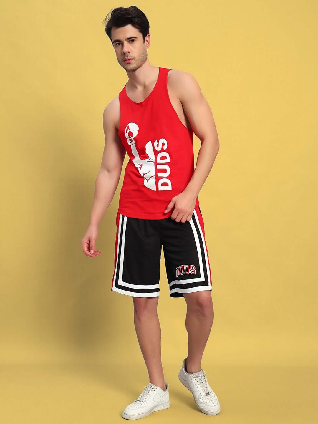Man wearing a red and black MAX GYM CO-ORD SET, featuring a cotton vest and polyester shorts, ideal for casual sports activities.