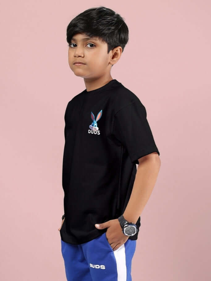 Young boy wearing a black Tiny Toon printed T-shirt by DUDS, ideal for boys and girls, featuring vibrant design, custom fit option available.