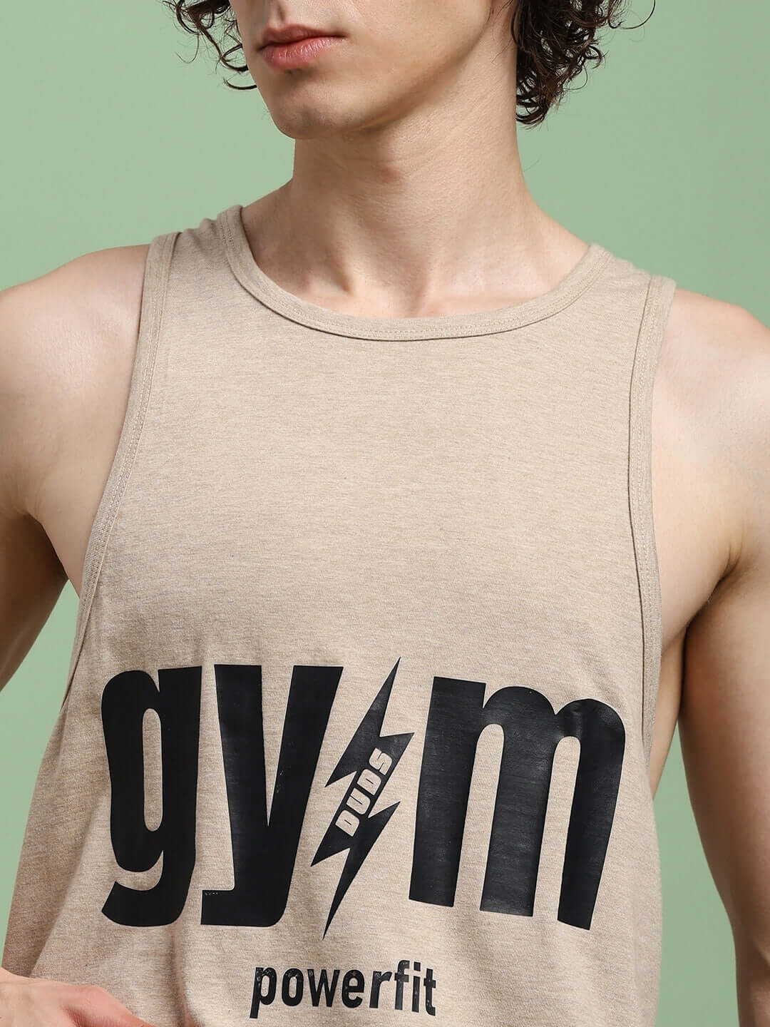 Male model wearing beige POWERFIT FITNESS gym t-shirt showcasing bold black logo on chest.