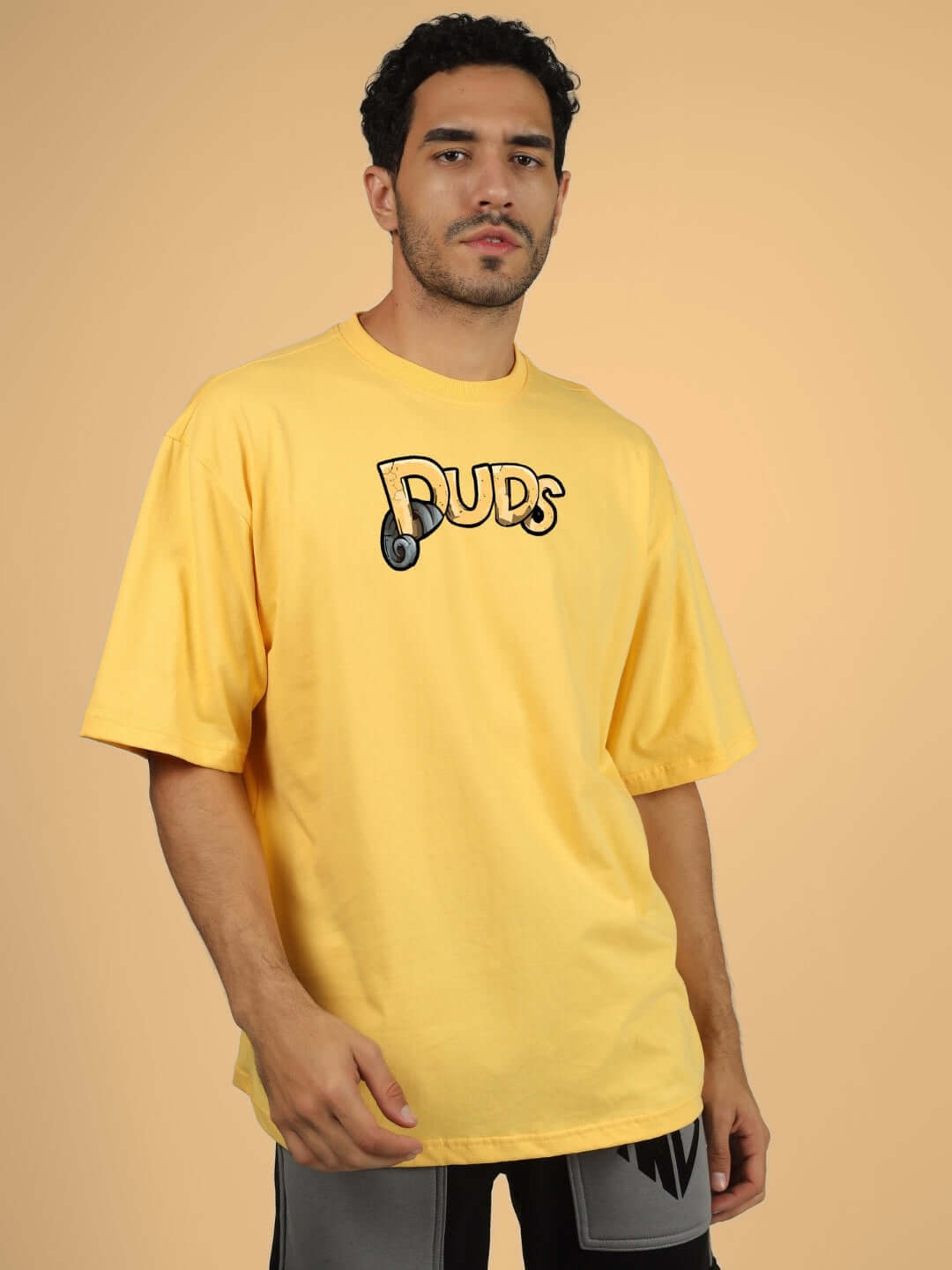 DUCK TALES OVER-SIZED T-SHIRT YELLOW over-sized tee in vibrant yellow with 'DUDS' logo, perfect for casual wear.