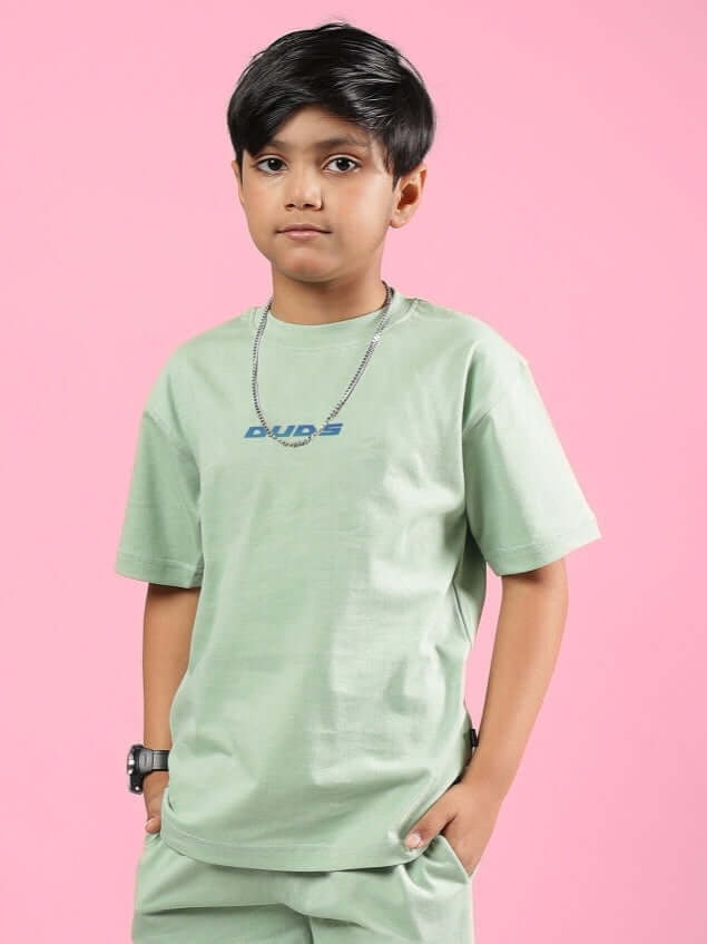 Child wearing a Nyanza Green PRAY & PEACE T-Shirt from DUDS, showcasing casual comfort and style for boys and girls.
