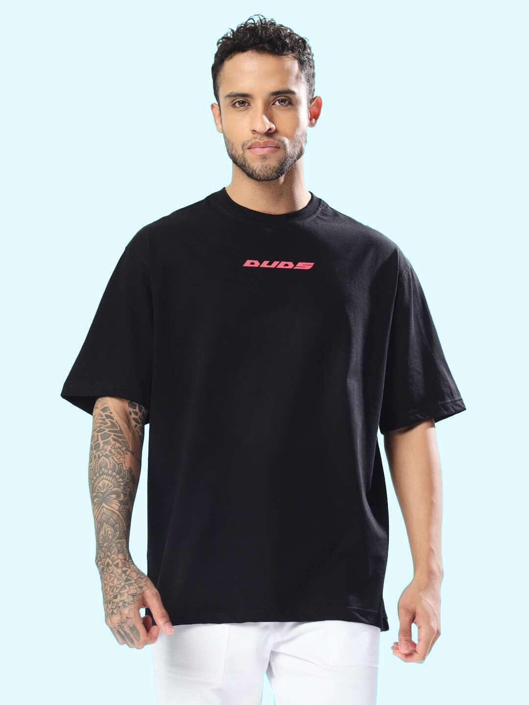 Man wearing MAKE IT POSSIBLE OVER-SIZED T-SHIRT BLACK with logo, custom fit option available, styled in casual modern fashion.