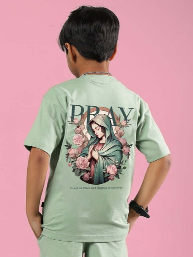 Child wearing Nyanza Green Pray & Peace T-shirt, featuring religious artwork on back, designed for boys and girls by DUDS.