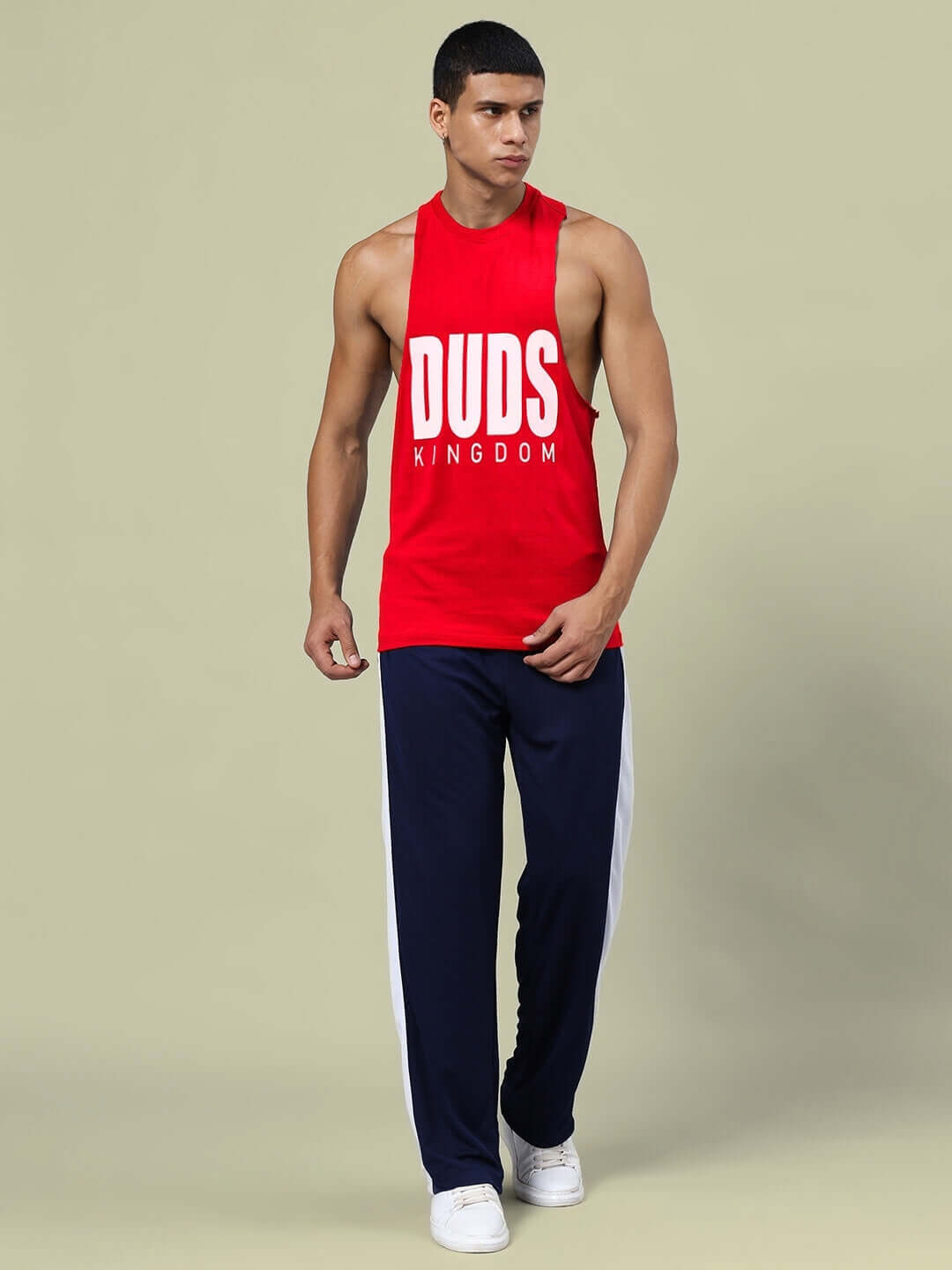 Model wearing DUDS KINGDOM gym co-ord set in red and navy-blue with relaxed fit joggers, showcasing unisex athletic fashion.