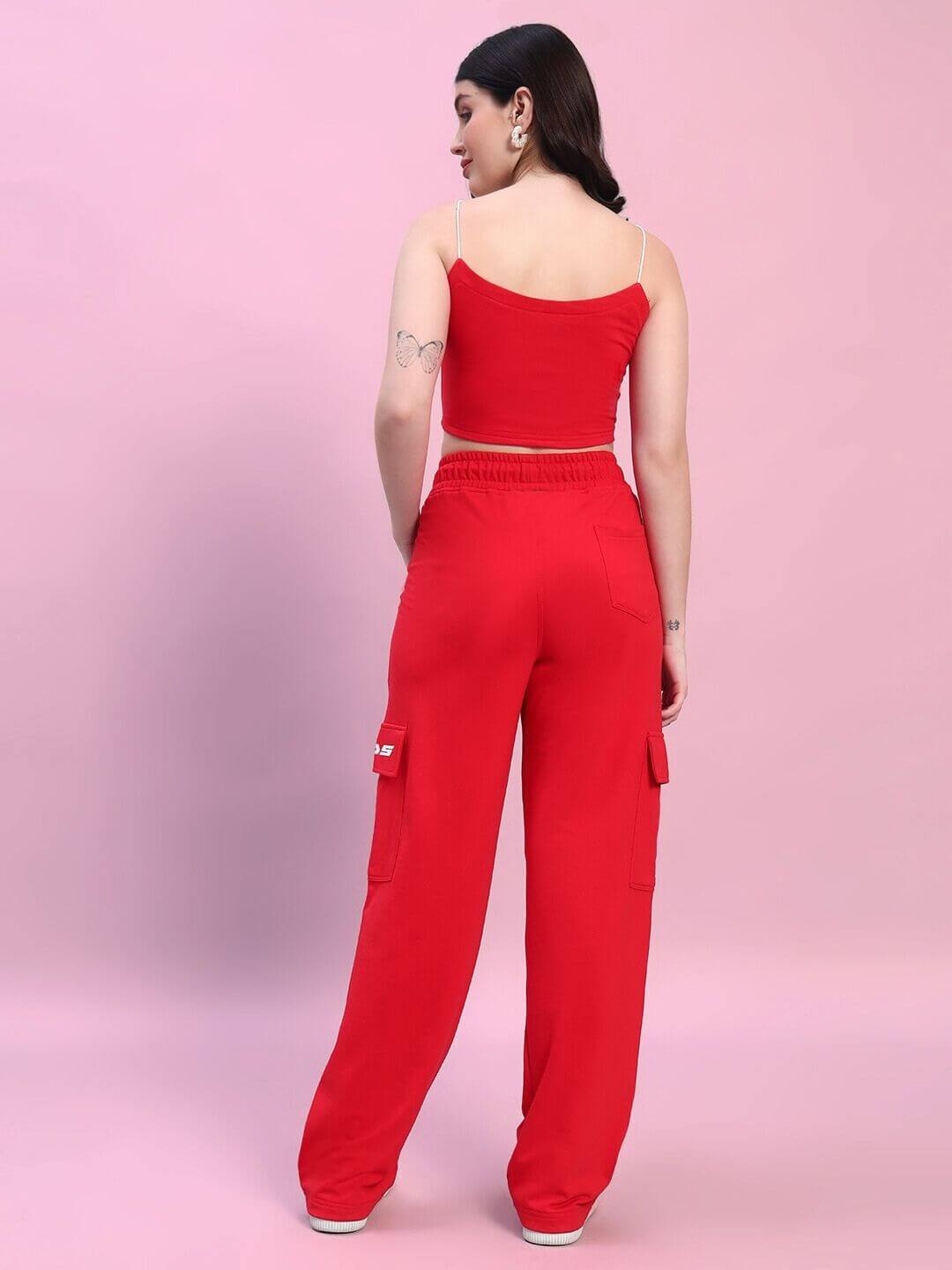 Woman wearing a red Rosella co-ord set, consisting of a sleeveless top and pants, made of premium cotton blend fabric. Fashionable outfit.
