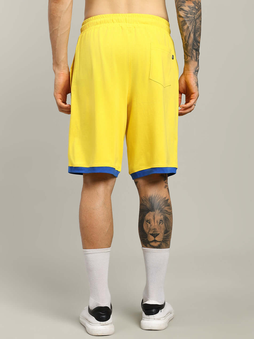 Man wearing Super Hero Summer Shorts in yellow, showcasing back view with blue trim, highlighting custom fit option for personalized sizing.