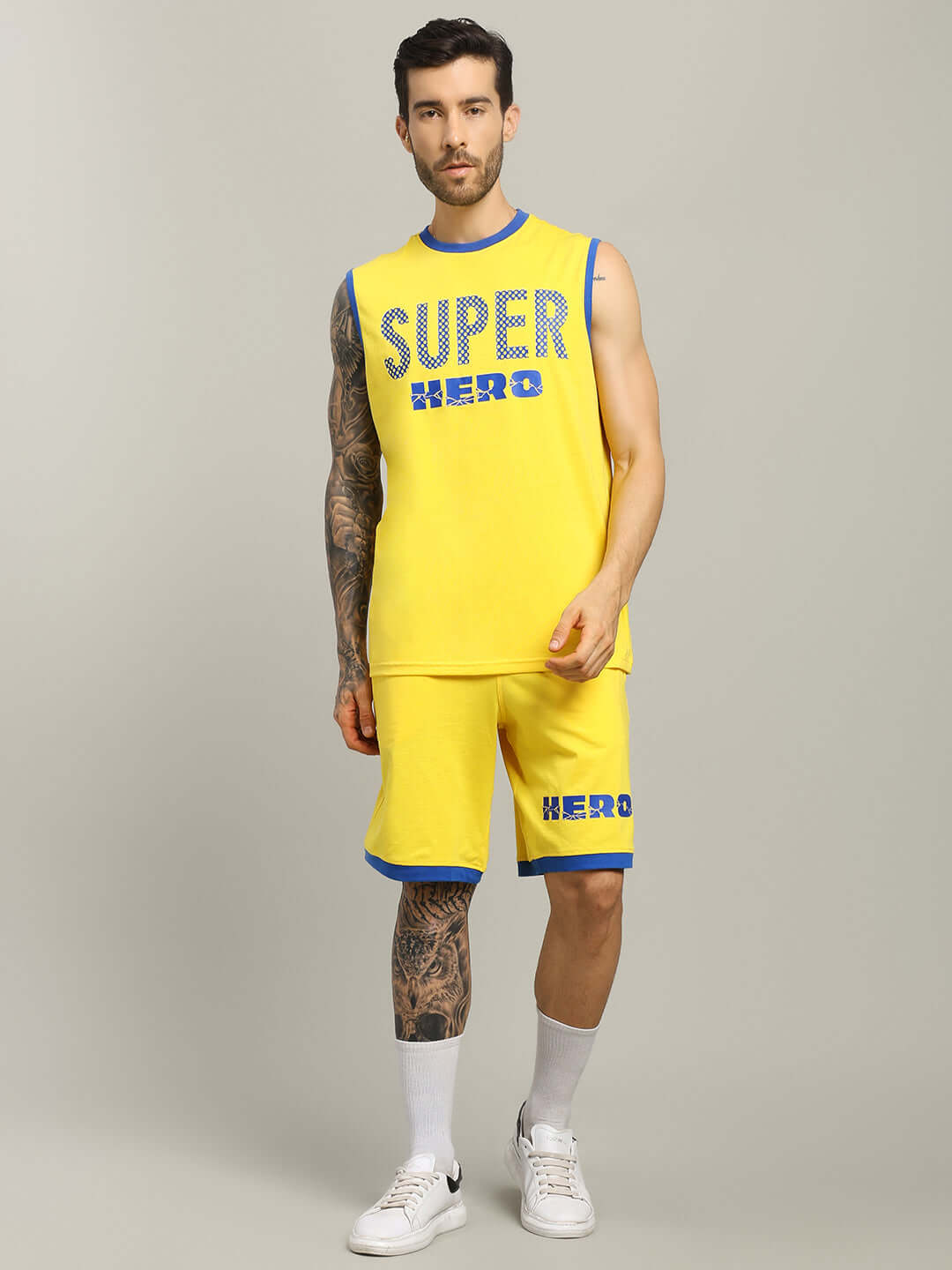 Man wearing yellow SUPER HERO SUMMER SHORTS and matching top, showcasing stylish summer outfit with custom fit option, front view.