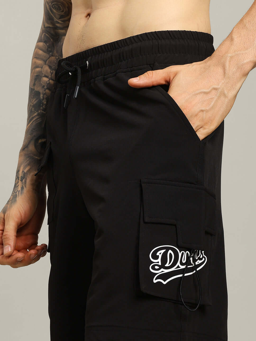 Side view of black VEGA cargo shorts with pockets, featuring 'Duds' logo, highlighting the custom fit option for prepaid orders.