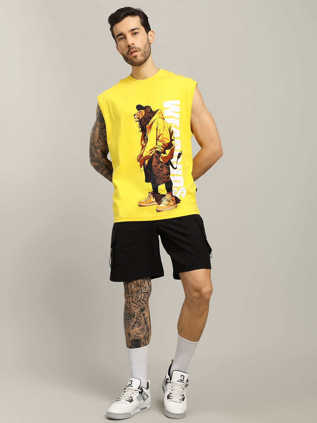 Model wearing black VEGA cargo shorts with yellow graphic tank top, showcasing casual style and customizable fit options.