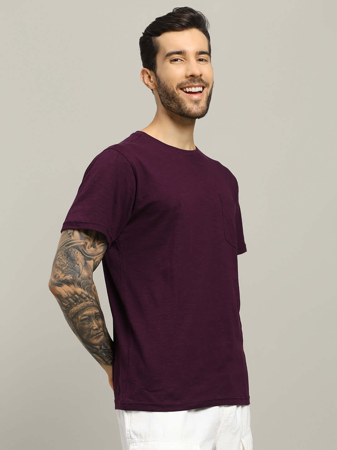 Man wearing JOY purple regular fit t-shirt with tattooed arm, made from 100% premium heavy cotton slub fabric, smiling and posing.