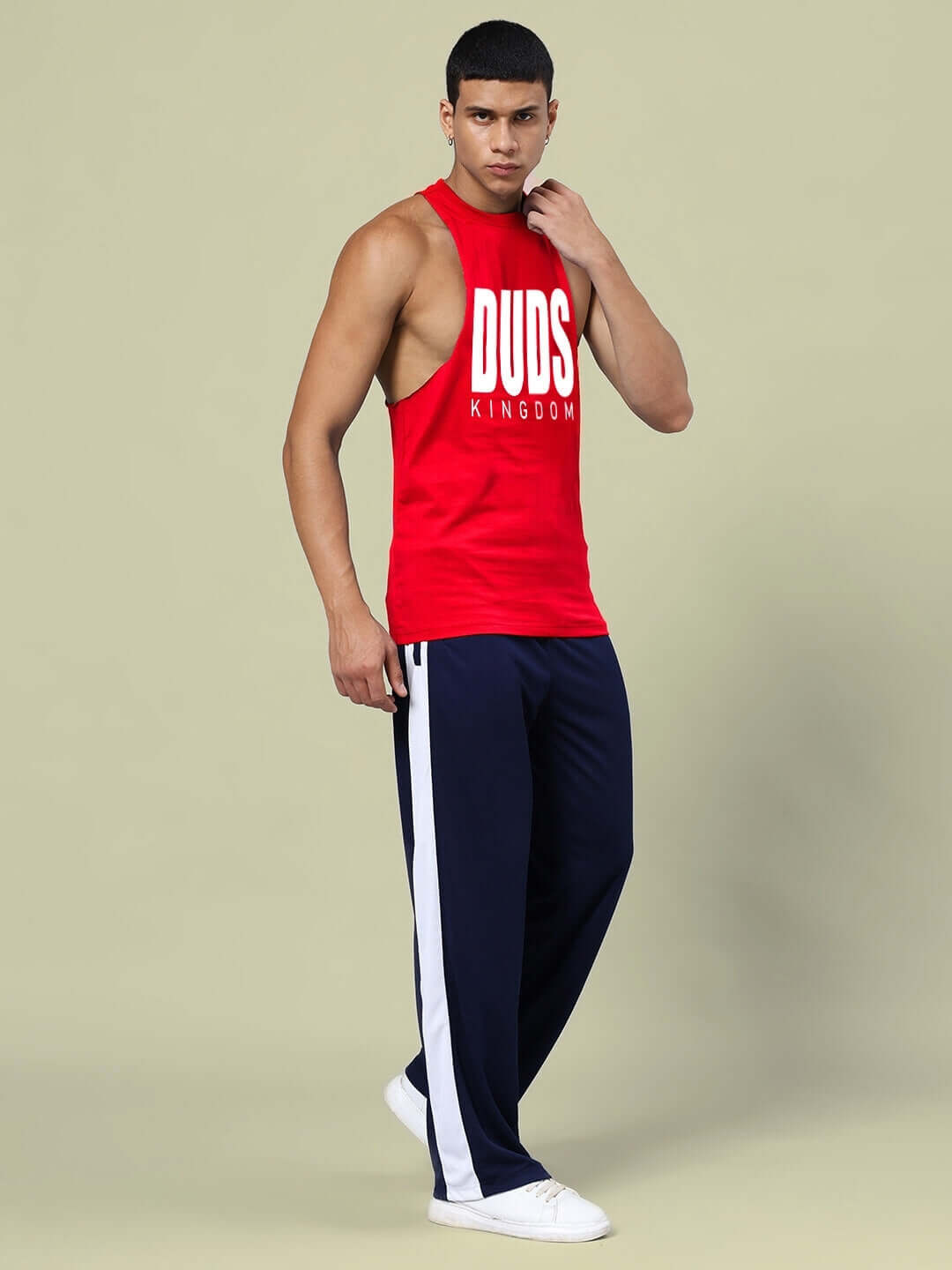 Model wears DUDS KINGDOM red tank and navy-blue joggers co-ord set; unisex, relaxed fit, with elasticated waistband.