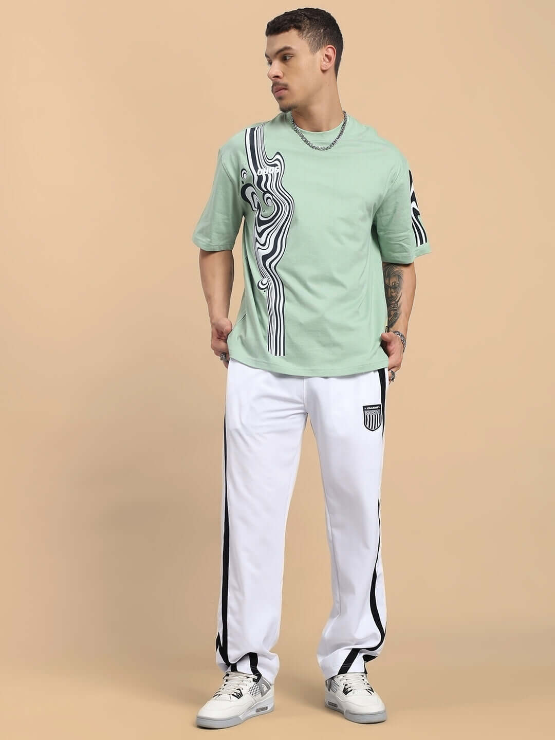 Model wearing FRIZZLE Relaxed Fit Jogger in white with a stylish t-shirt, showcasing comfortable made-to-order apparel from DUDS.