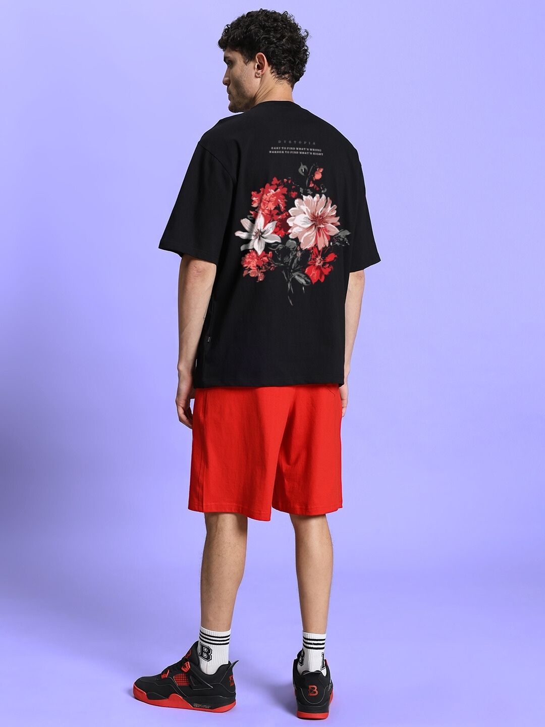 Back view of FLORAL PRINTED SUMMER CO-ORD SET BLACK RED on a model with floral design on black shirt and red shorts.