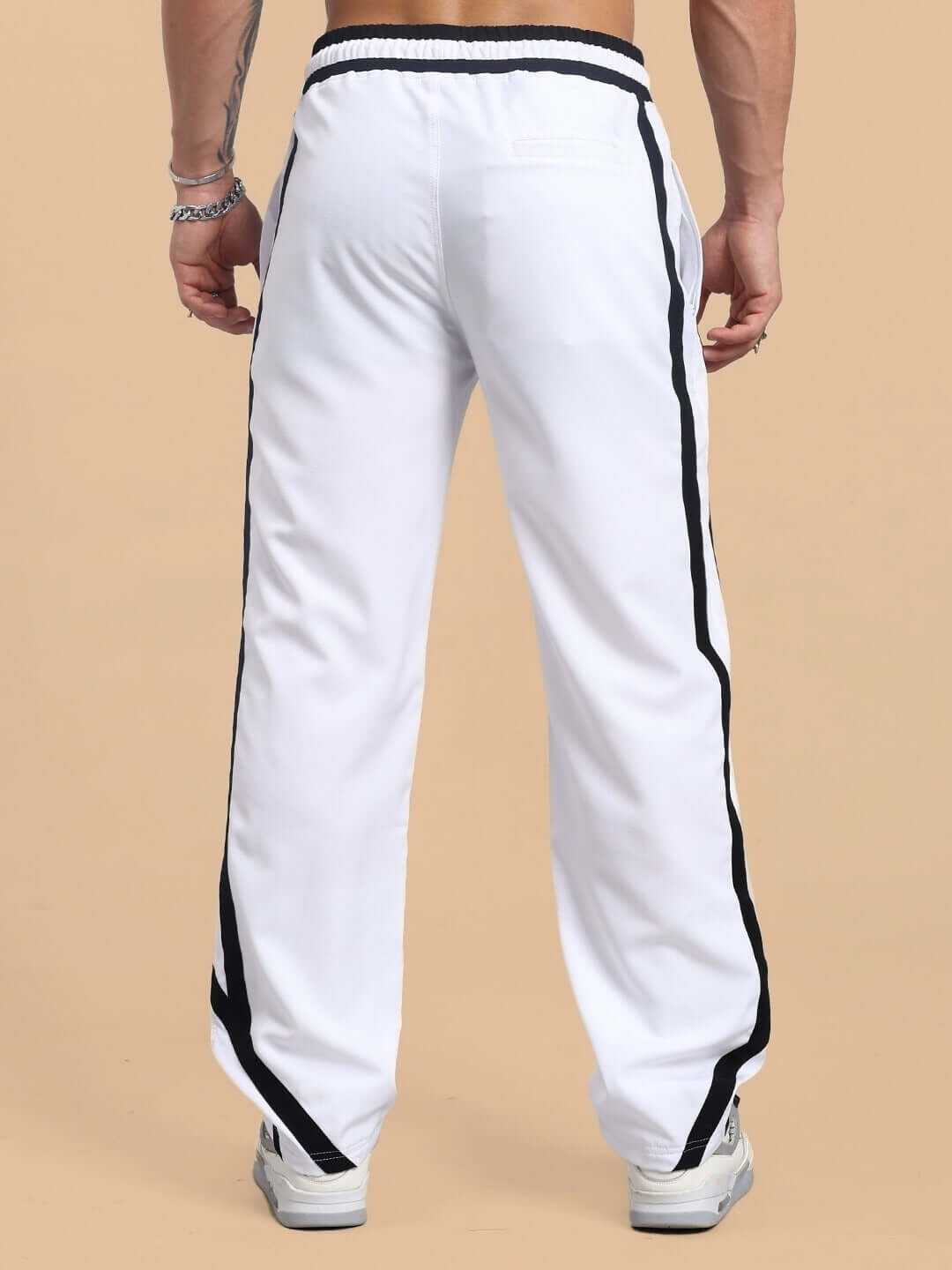 Rear view of Frizzle Relaxed Fit Jogger in white, with black stripe detail, worn by a male model, showcasing tailored fit and comfort.