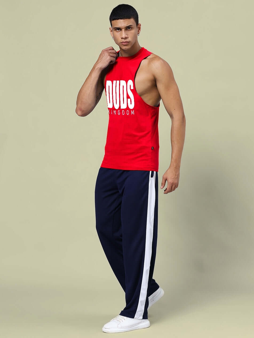 Model wearing DUDS KINGDOM gym co-ord set in red and navy-blue, featuring relaxed fit joggers with elastic waistband and drawstring.
