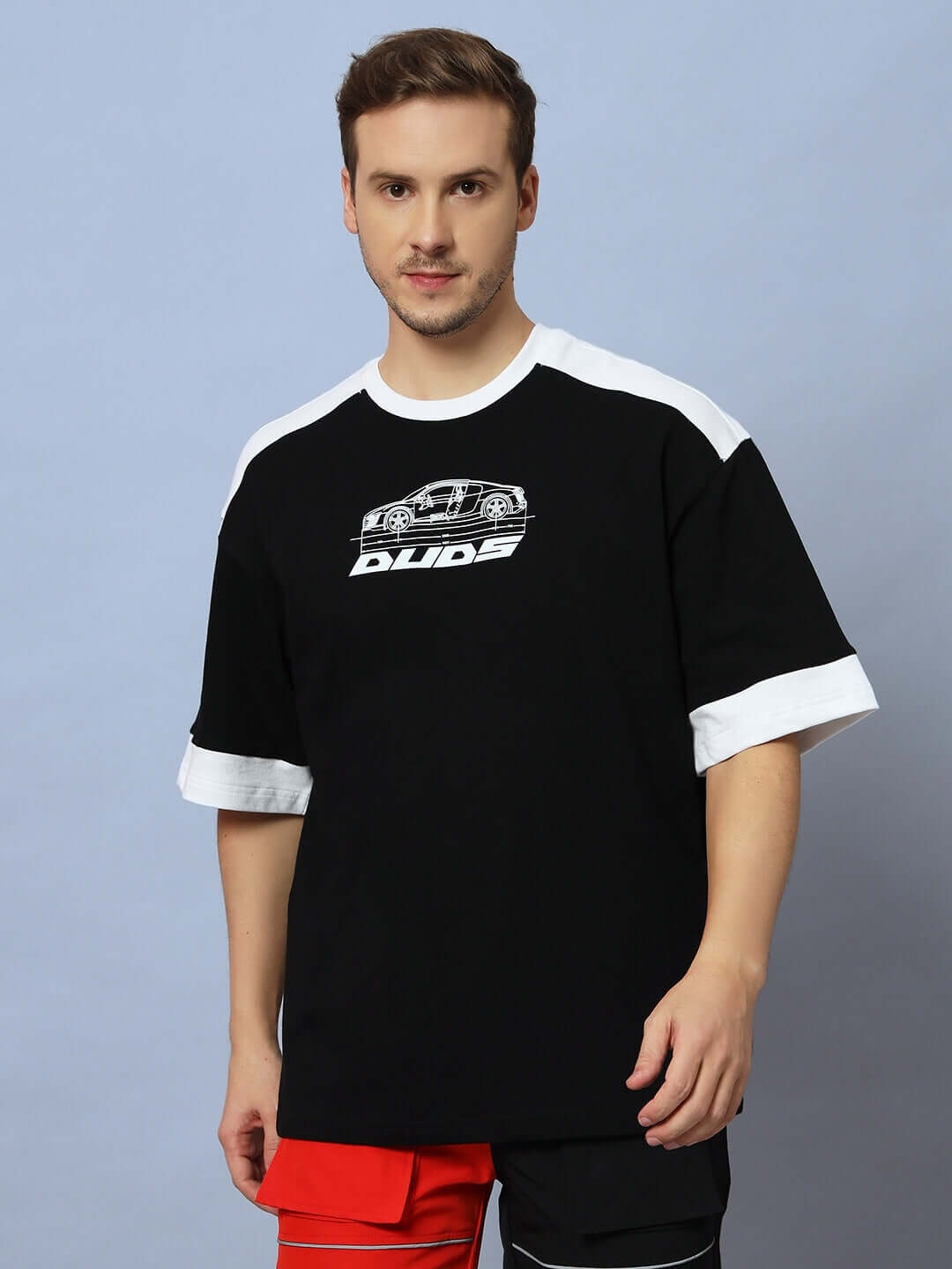 Model wearing AUDI R8 OVERSIZED T-SHIRT BLACK with Audi R8 graphic, featuring dropped shoulders and wide sleeves for a casual look.