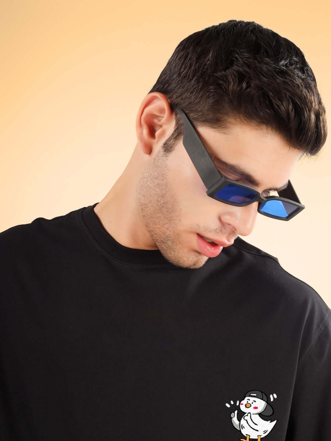 Model wearing GO MOTION OVER-SIZED T-SHIRT BLACK with unique design, featuring stylish sunglasses and custom fit option available.